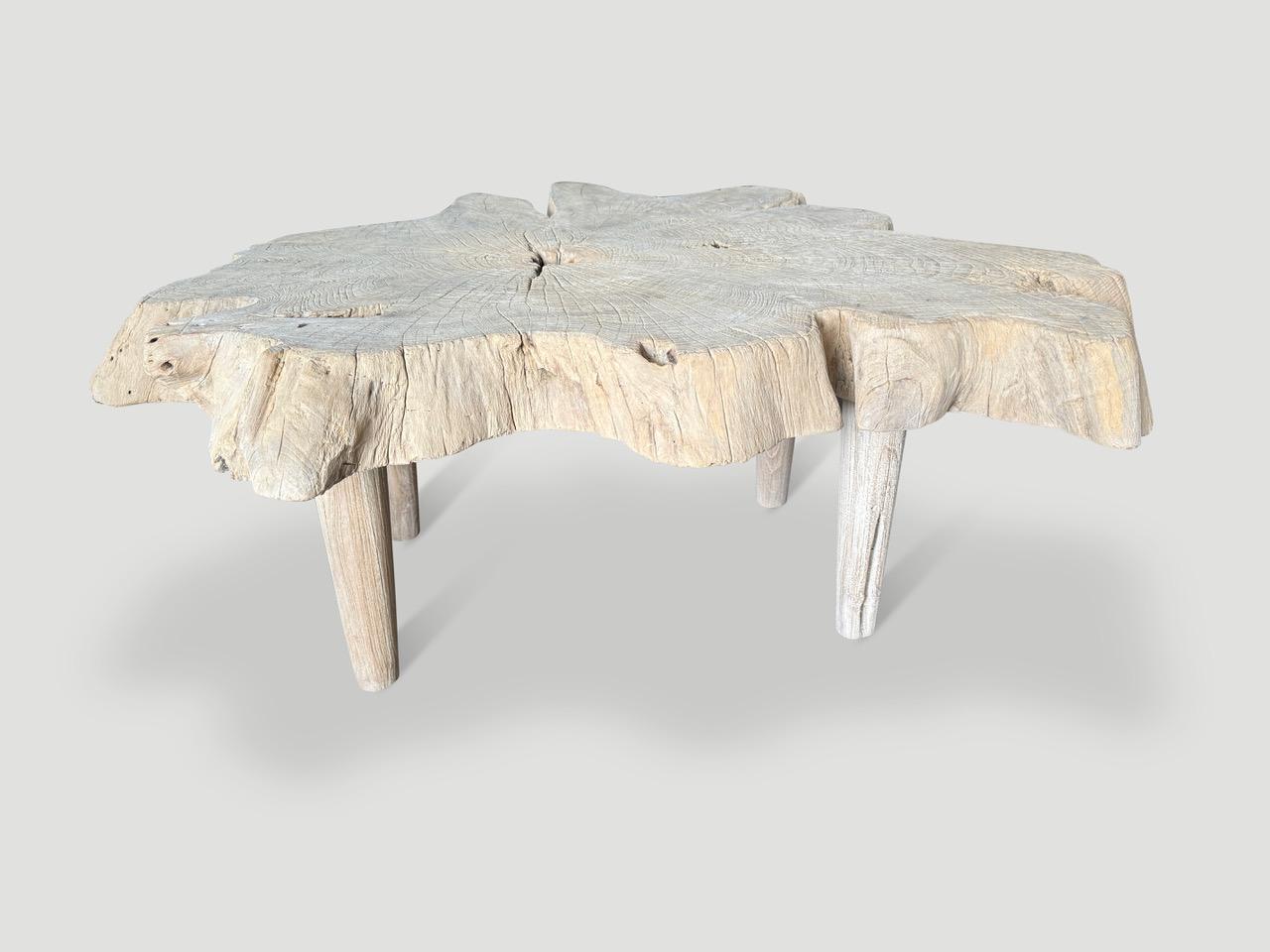 Impressionnante table basse en teck massif de quatre pouces et demi. Nous avons blanchi le magnifique bois de teck centenaire et ajouté une brosse métallique et un ingrédient secret révélant le grain unique du bois. Flottant sur des pieds de style