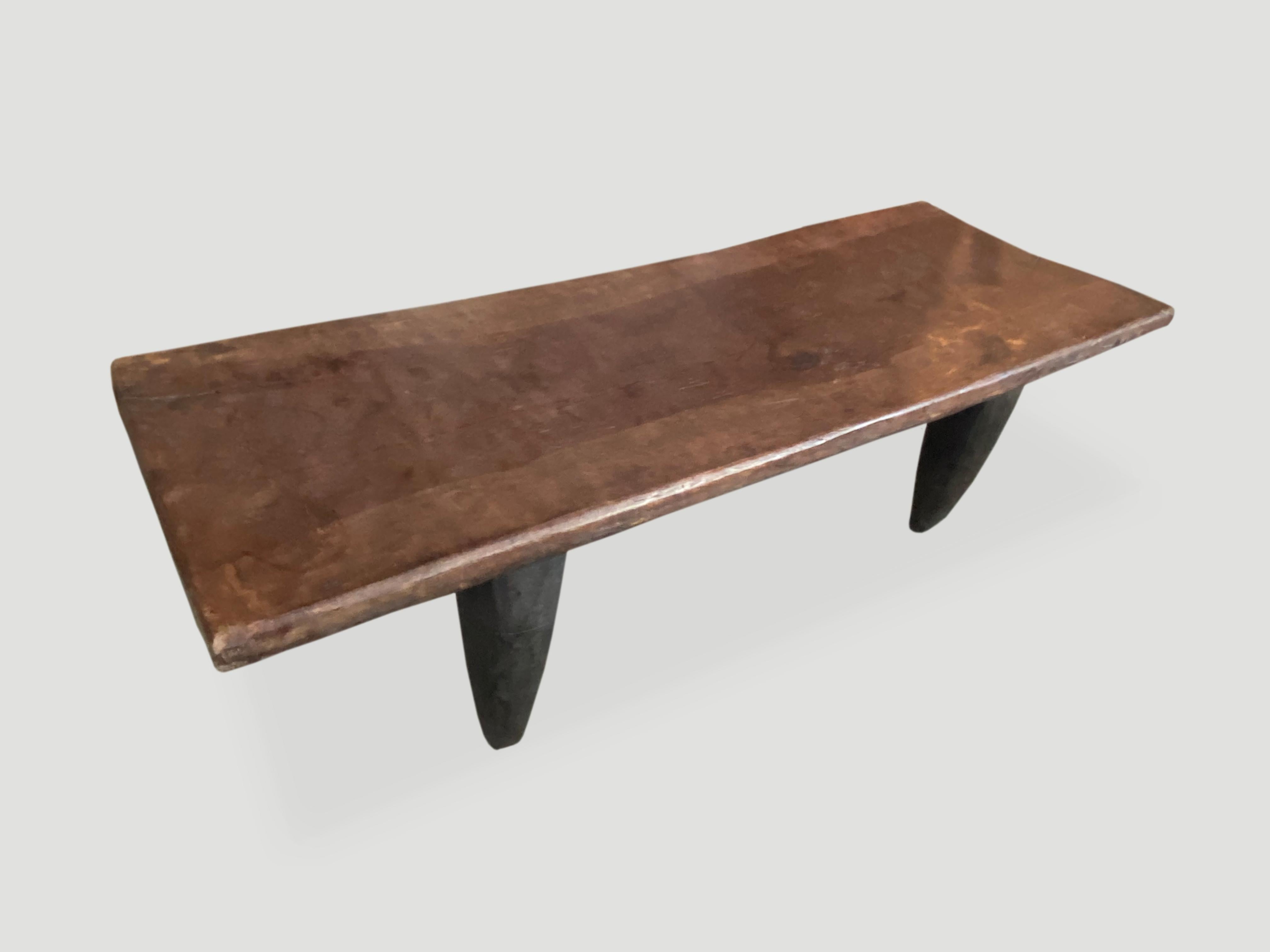Antique bench or coffee table hand carved by the Senufo tribes from a single piece of iroko wood, native to the west coast of Africa. The wood is tough, dense and very durable. Shown with cone style legs.

This bench or coffee table was sourced in