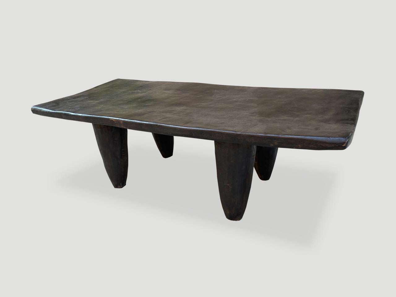 Antique bench or coffee table hand carved by the Senufo tribes from a single block of iroko wood, native to the west coast of Africa. The wood is tough, dense and very durable. Shown with cone style legs and stained espresso. We only source the
