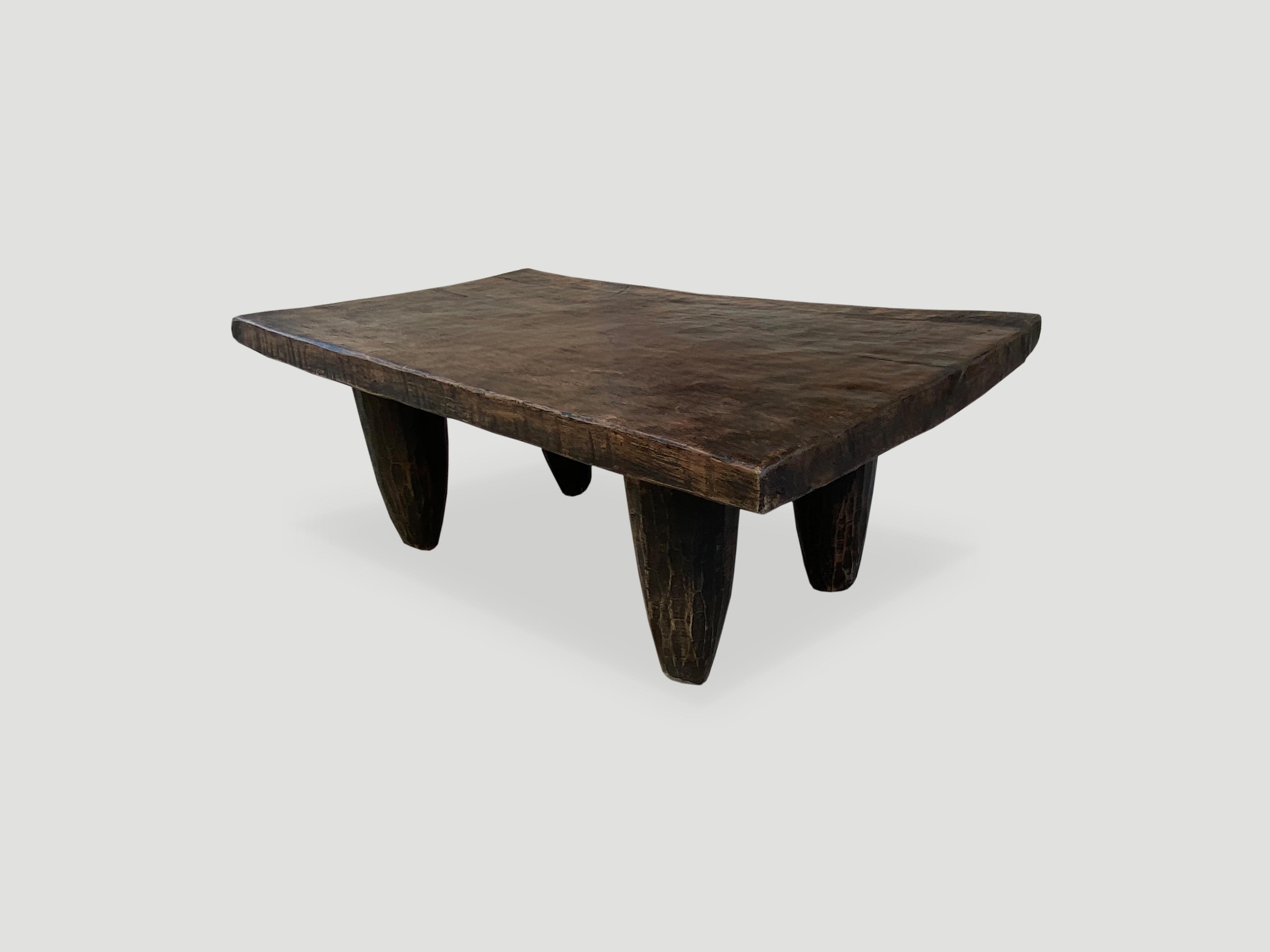 Antique bench or coffee table hand carved by the Senufo tribes from a single block of iroko wood, native to the west coast of Africa. The wood is tough, dense and very durable. Shown with cone style legs. We only source the best. 

This bench or