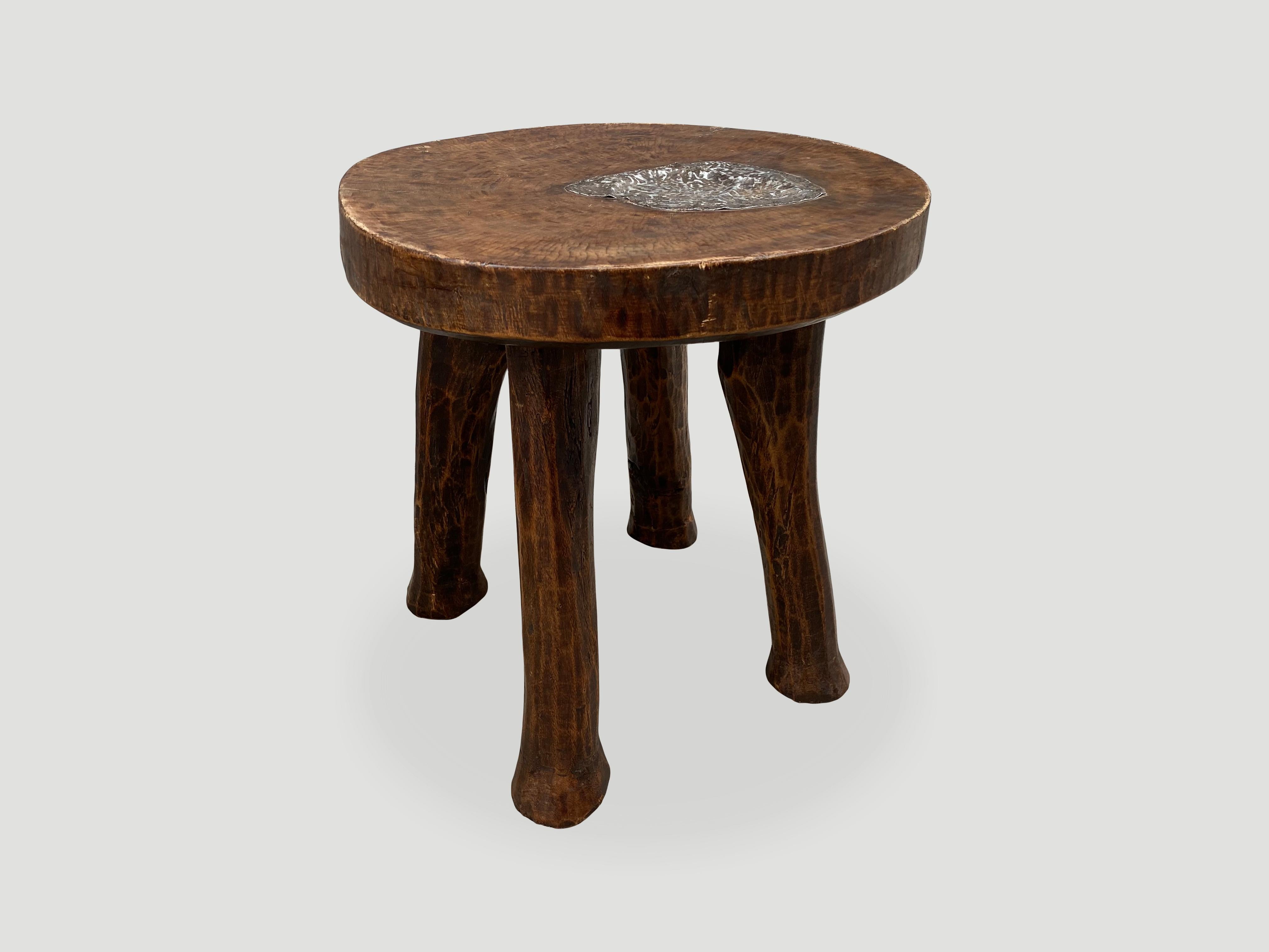 Antique African mahogany side table, hand carved from a single block of mahogany wood with lovely patina and tin overlay. A beautiful, versatile item that is both sculptural and usable. We only source the best.

This side table was sourced in the