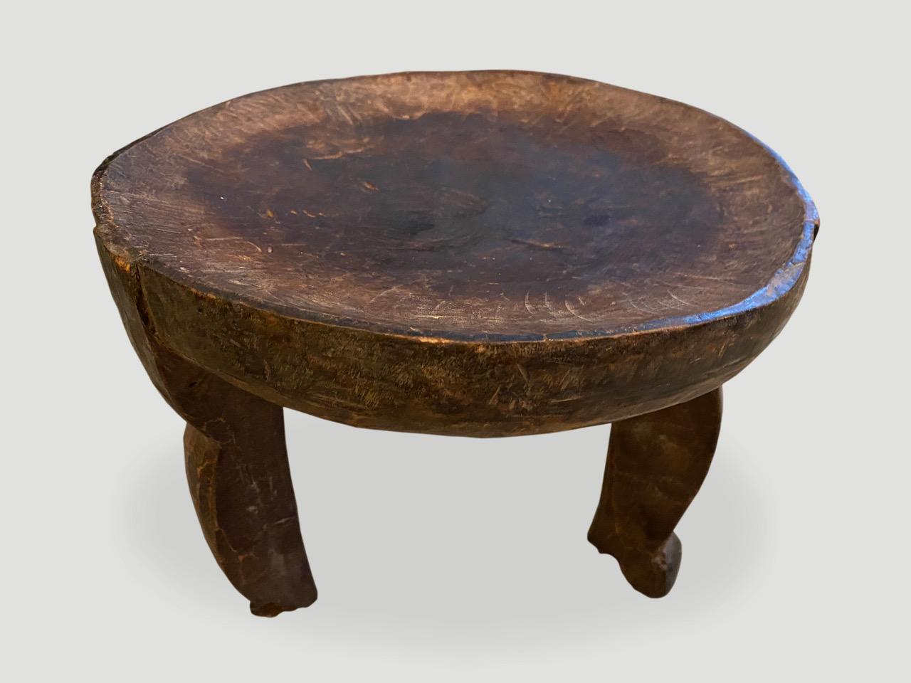 Beautiful hand carved African side table or stool with lovely patina. The entire piece is hand carved out of a single piece of mahogany wood.

This stool or side table was sourced in the spirit of wabi-sabi, a Japanese philosophy that beauty can