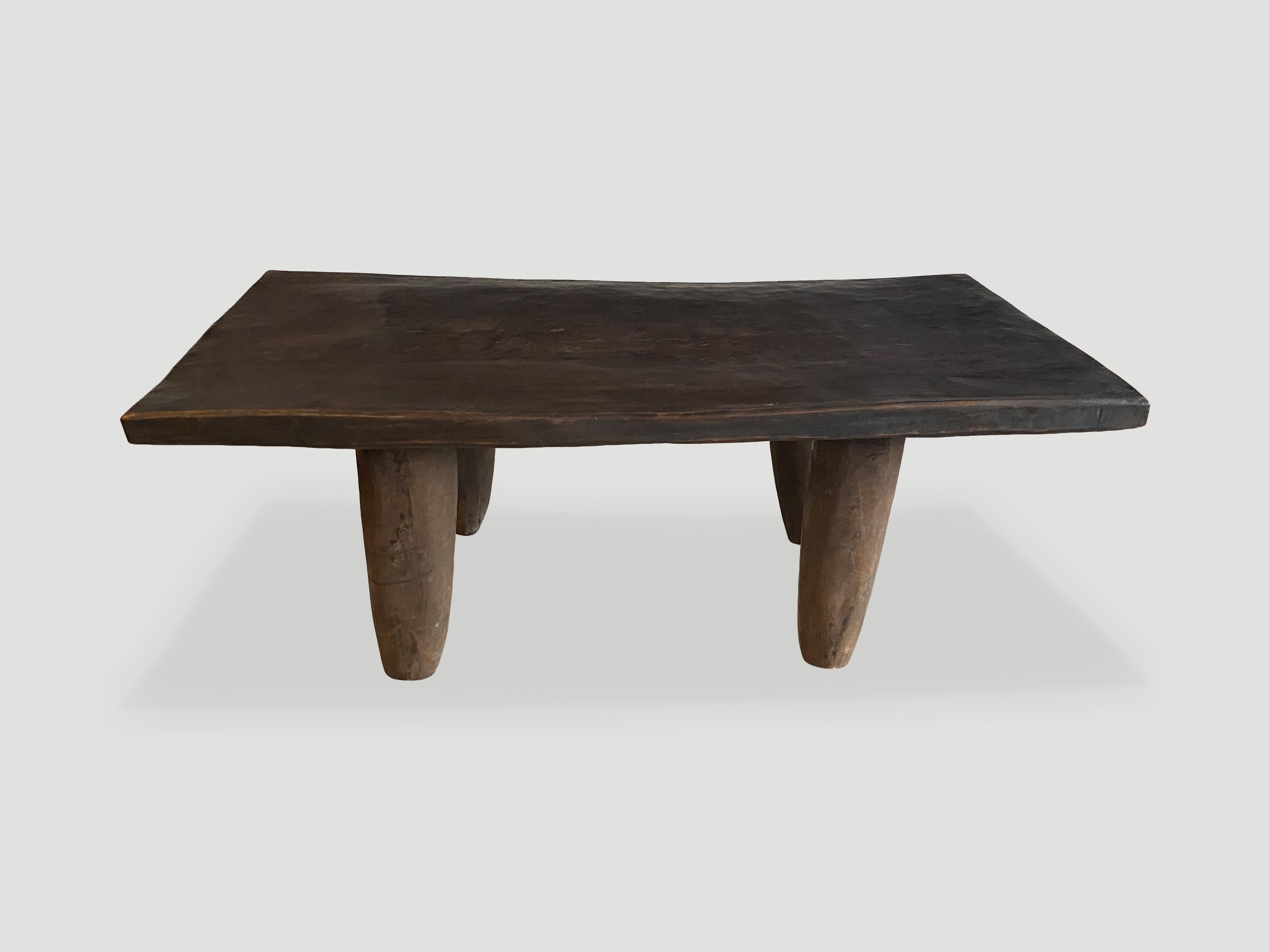 Antique coffee table hand carved by the Senufo tribes from a single block of Iroko wood, native to the west coast of Africa. The wood is tough, dense and very durable. Shown with cone style legs. We only source the best. This one is beautiful, wider