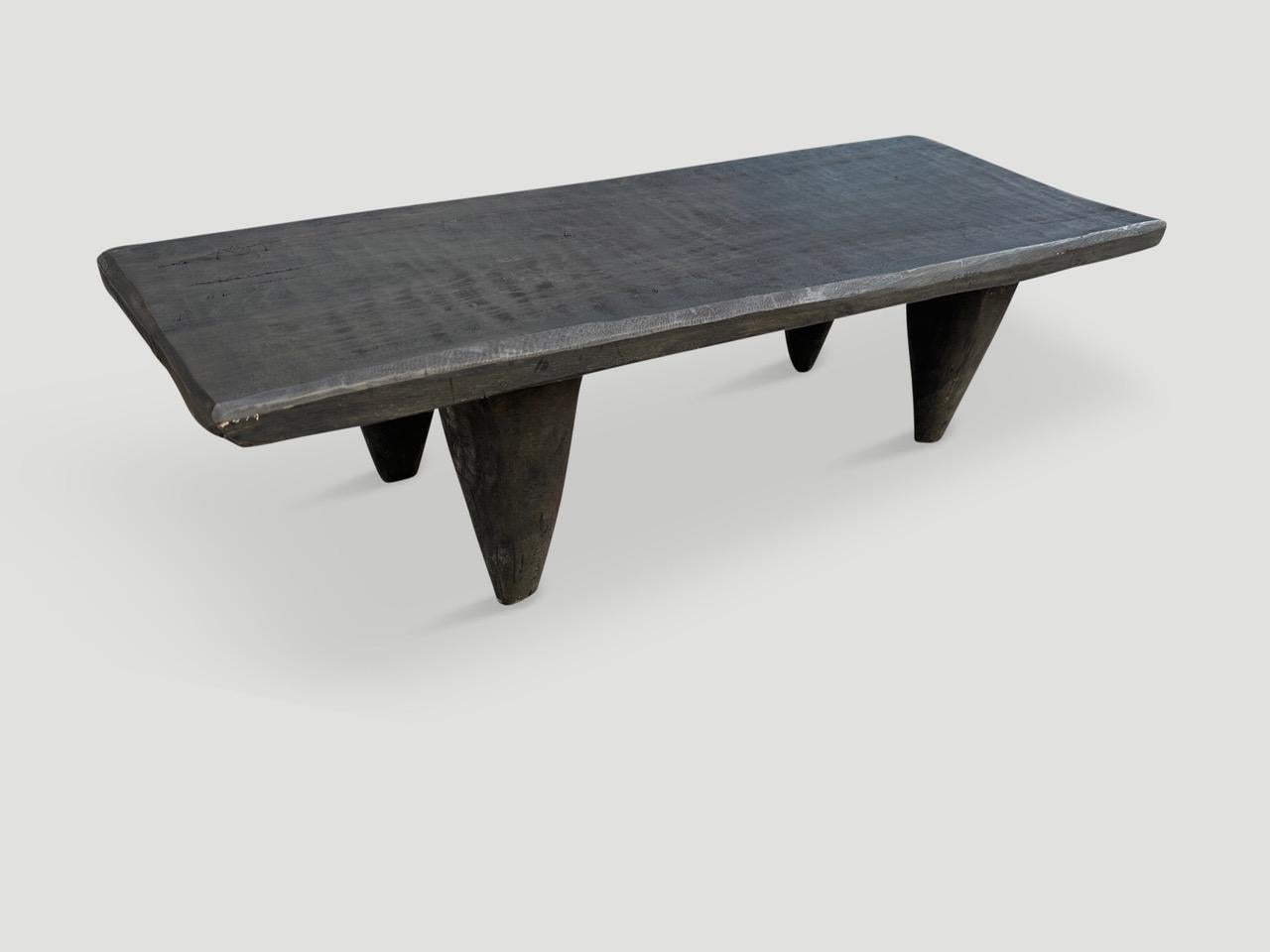 Antique coffee table or bench hand carved by the Senufo tribes from a single block of Iroko wood, native to the west coast of Africa. The wood is tough, dense and very durable. Shown with cone style legs. We stained this one espresso. We only source