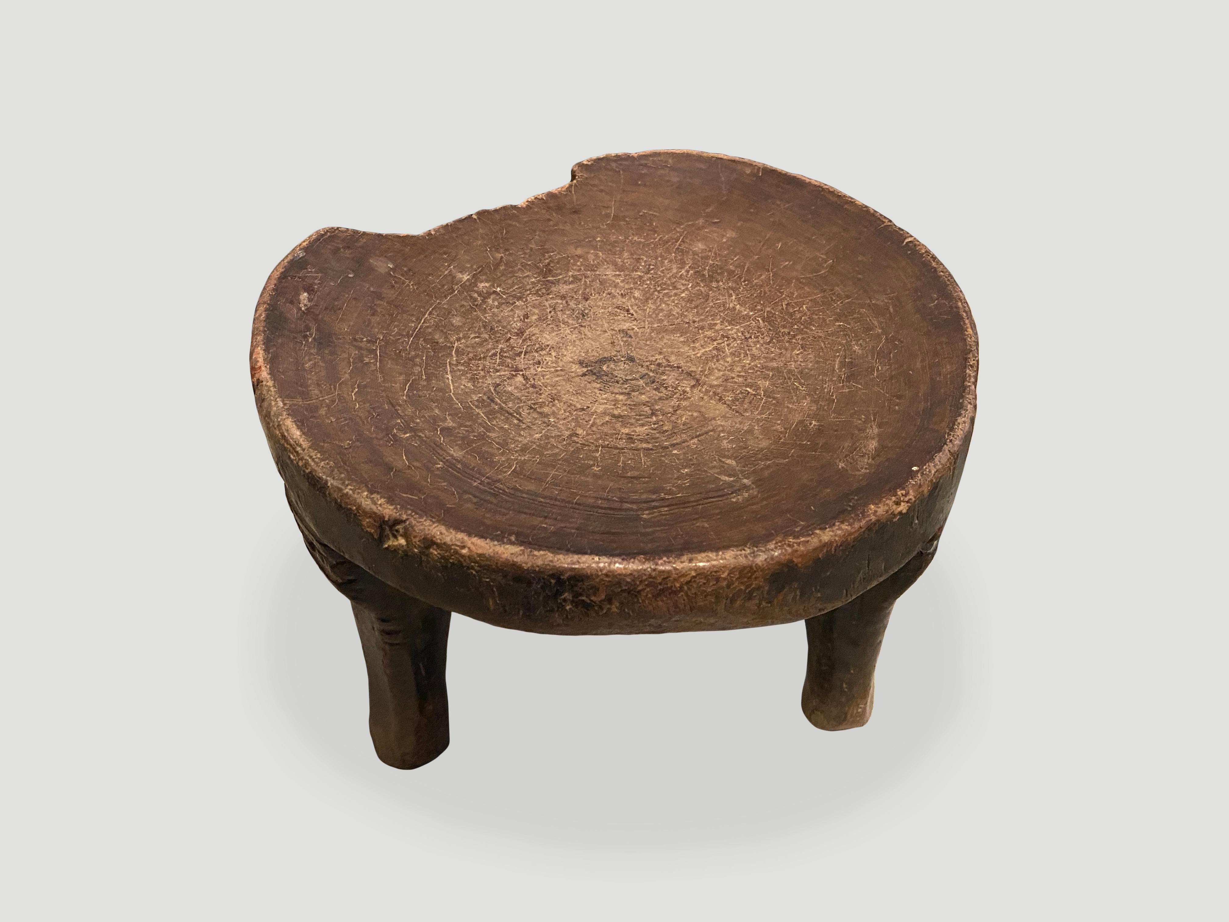 Beautiful patina on this African side table hand carved from a single block of wood. Celebrating the cracks and crevices and all the other marks that time and loving use have left behind. We only source the best. Circa 1900.

This side table was