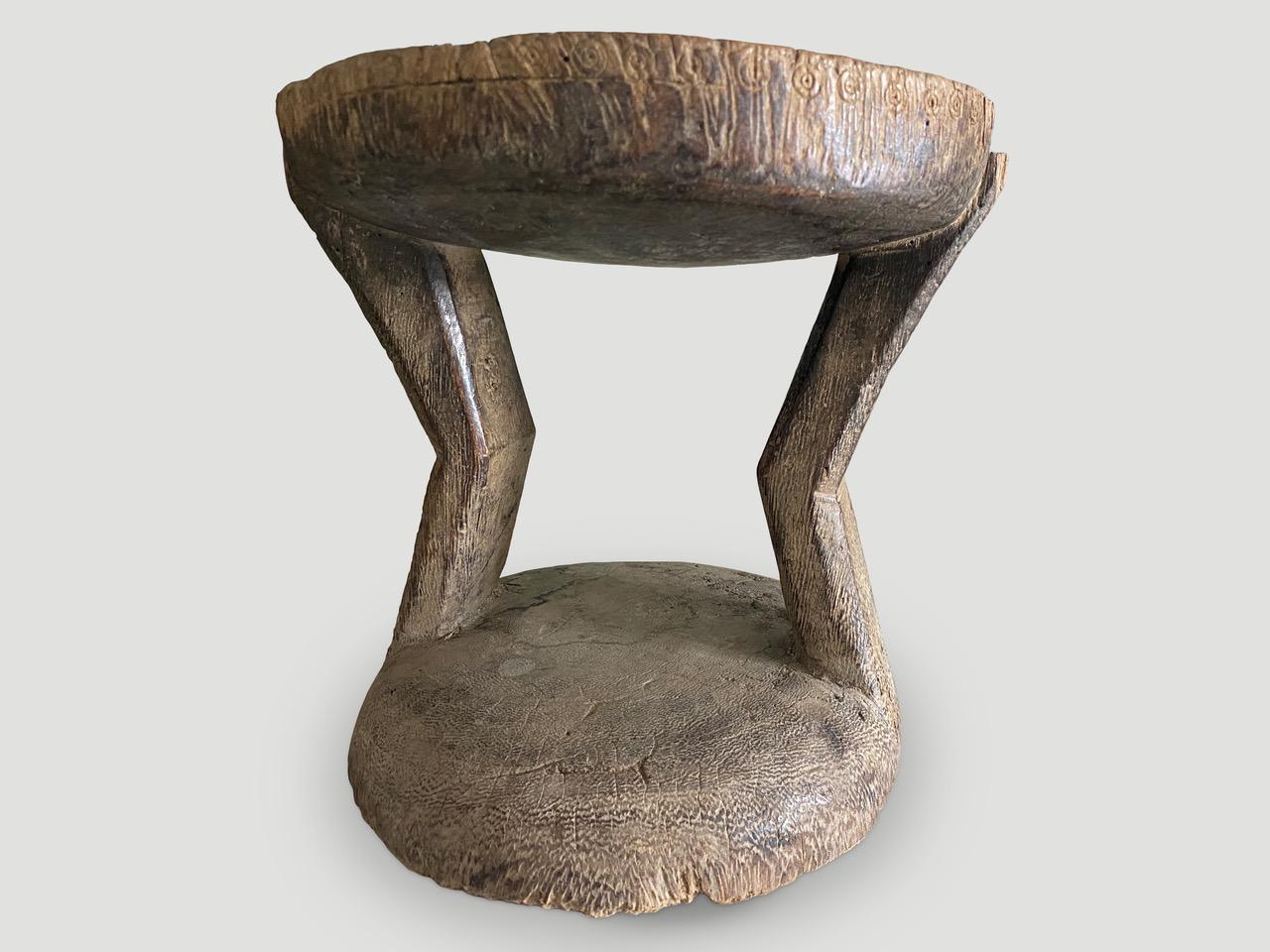 Beautiful hand carved African side table or stool with lovely patina and added tin appliqué on the top The entire piece is hand carved out of a single block of wood. A beautiful, versatile item that is both sculptural and usable

This stool or