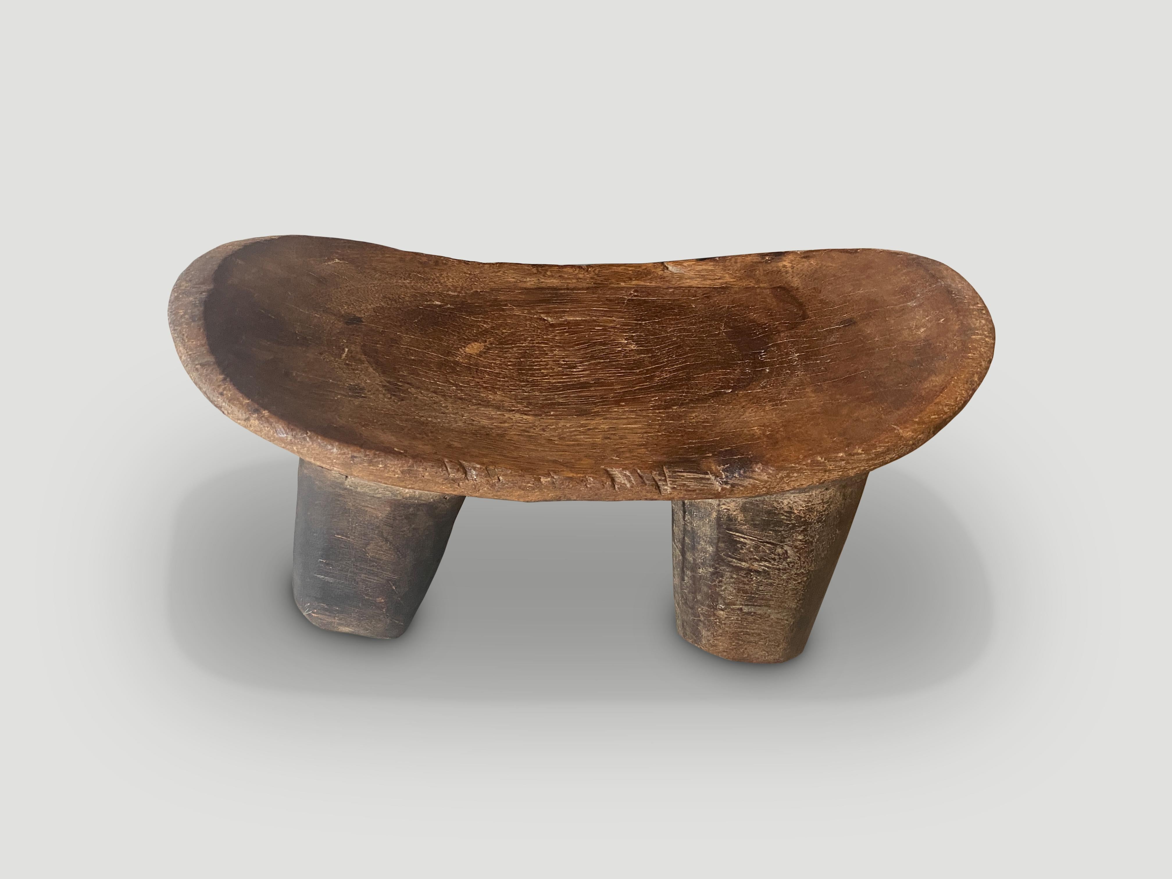 Beautiful African stool or side table hand carved from a single block of wood. Originally used as a head rest. Celebrating the cracks and crevices and all the other marks that time and loving use have left behind. Great for placing a book or perhaps