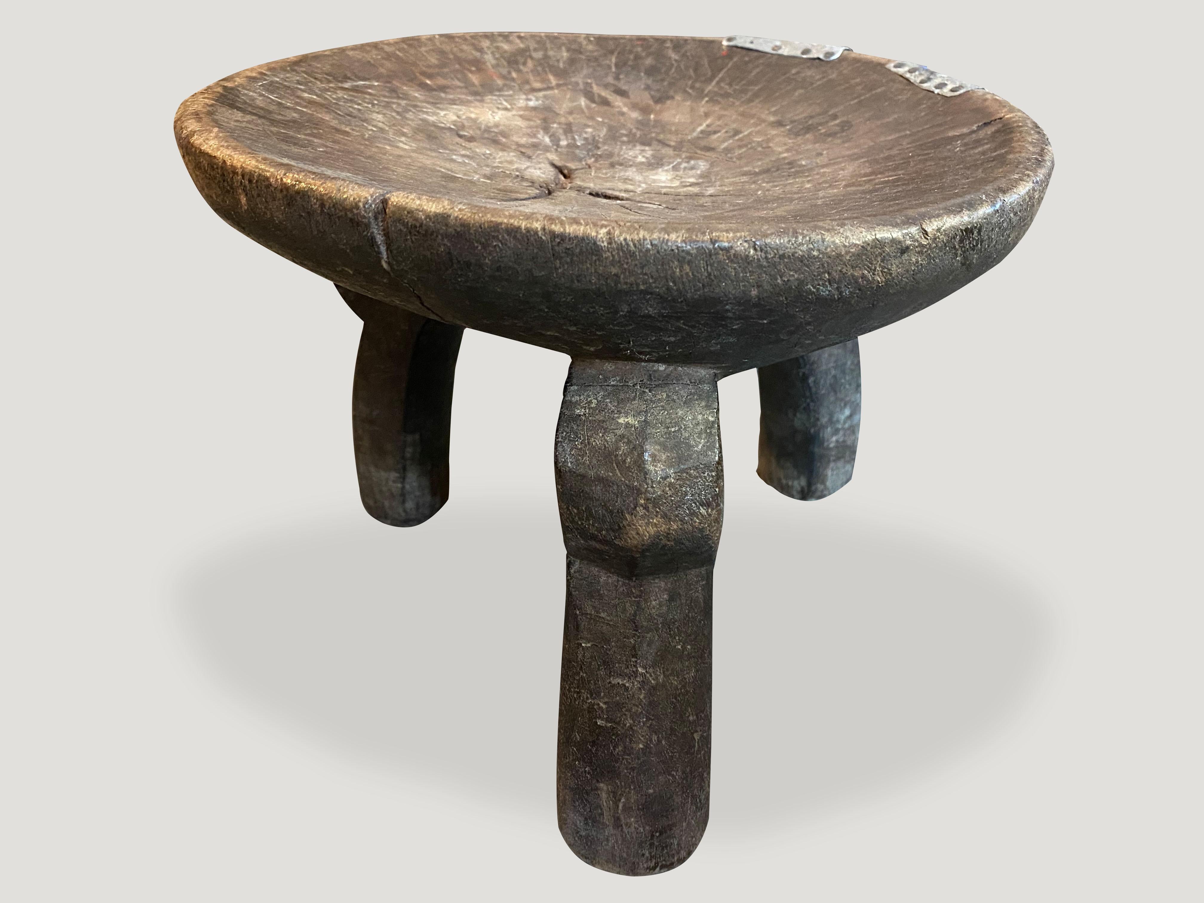 Beautiful hand carved African teak stool, side table or bowl with lovely patina and added tin overlay. The entire piece is hand carved out of a single block of wood.

This stool or bowl was sourced in the spirit of wabi-sabi, a Japanese philosophy