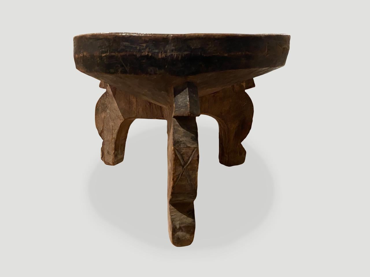 Beautiful patina on this African small tray side table hand carved from a single block of wood. Celebrating the cracks and crevices and all the other marks that time and loving use have left behind. We only source the best. Circa 1900.

This side