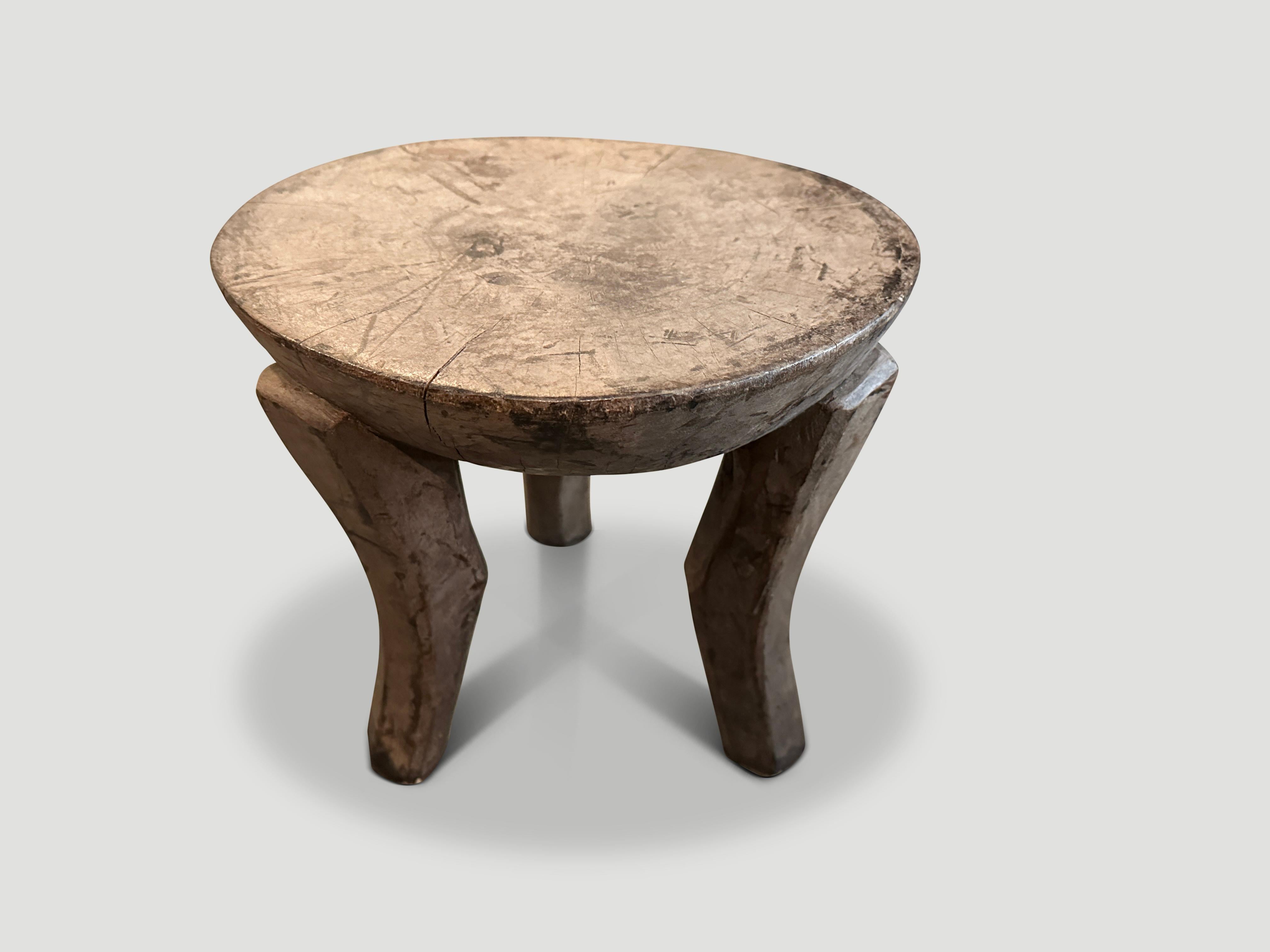 Antiker afrikanischer Beistelltisch mit milchigen Holztönen. Handgeschnitzt aus einem einzigen Holzblock.

Dieser Beistelltisch wurde im Geiste von Wabi-Sabi entworfen, einer japanischen Philosophie, die besagt, dass Schönheit in der