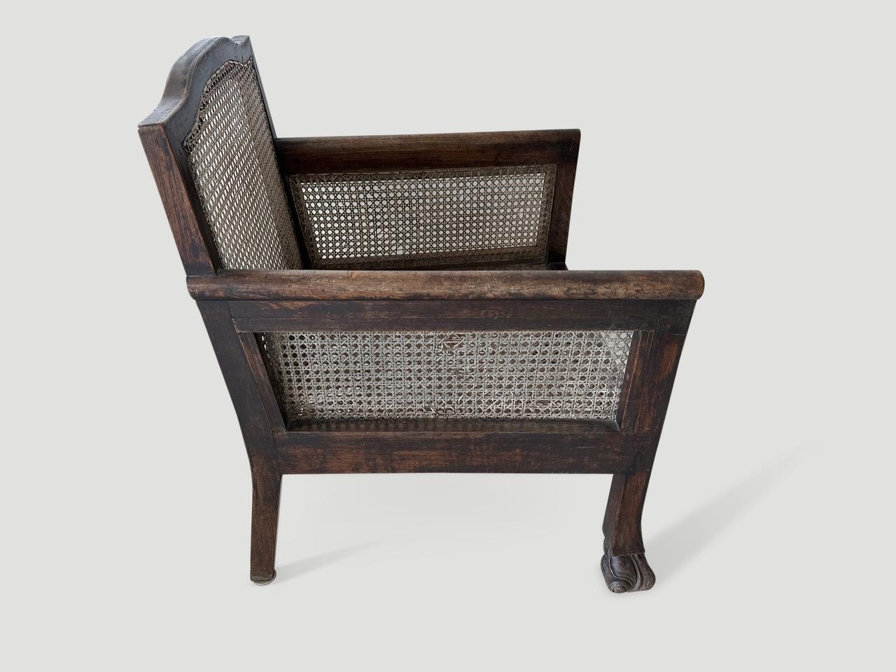 Beautiful teak framed colonial chair with lovely patina. Hand-carved feet and restored hand-woven rattan. A classic chair for any space. Includes a linen seat pillow. Full dimensions; 24