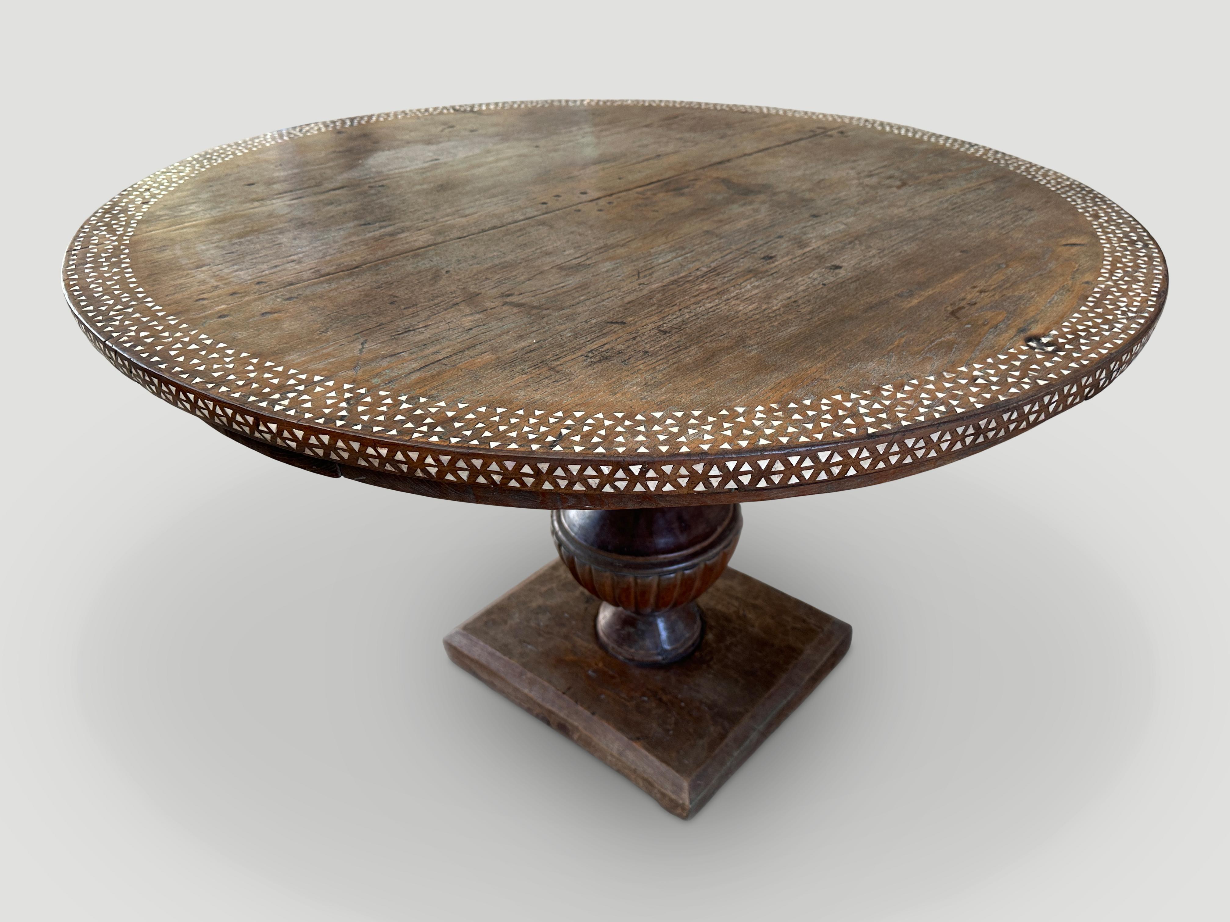 Impressive antique colonial teak wood round dining table or entry table. circa 1940. Beautiful hand carved base. We added the shell inlay to the top and edge. One of a kind. 

This table was handmade in the spirit of Wabi-Sabi, a Japanese