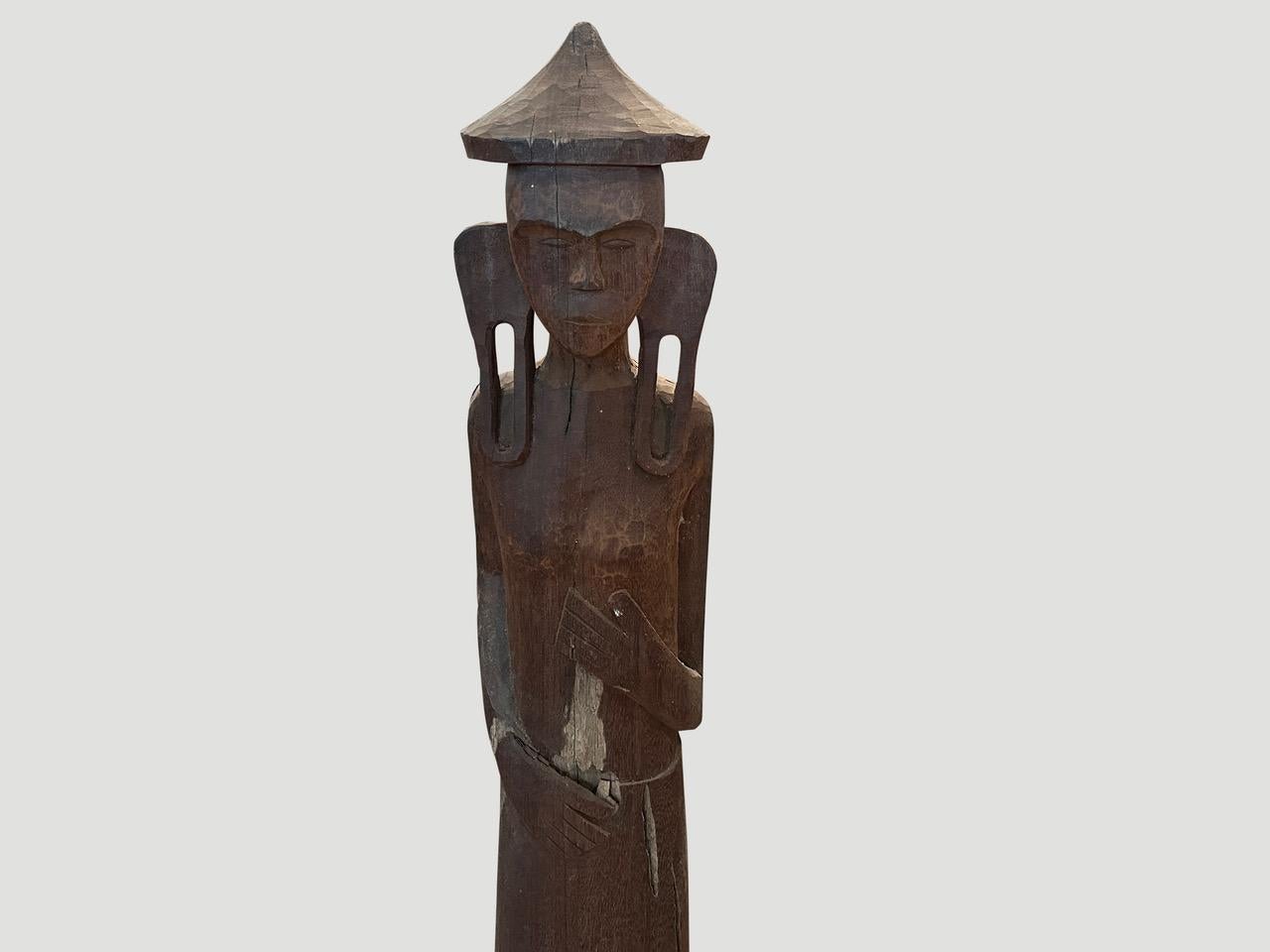 Antique male statue hand carved from a single wood log from West Borneo. Originally used to protect the home from evil spirits. The wood base was placed into the ground in front of the house as a guardian. We added an 8