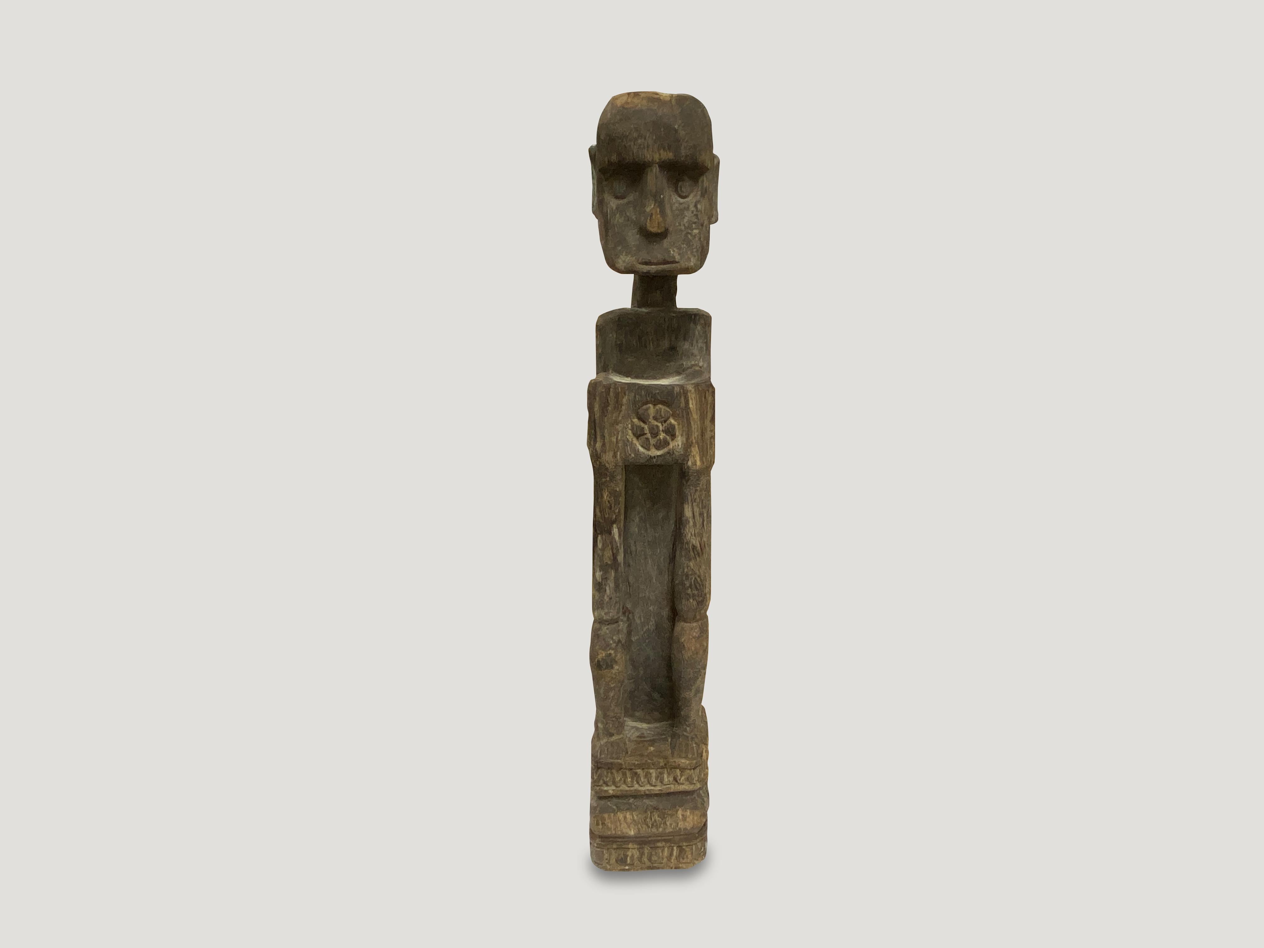 Antique hand carved statue of a primitive man from Sumatra, holding offerings. 

This statue was sourced in the spirit of wabi-sabi, a Japanese philosophy that beauty can be found in imperfection and impermanence. It is a beauty of things modest