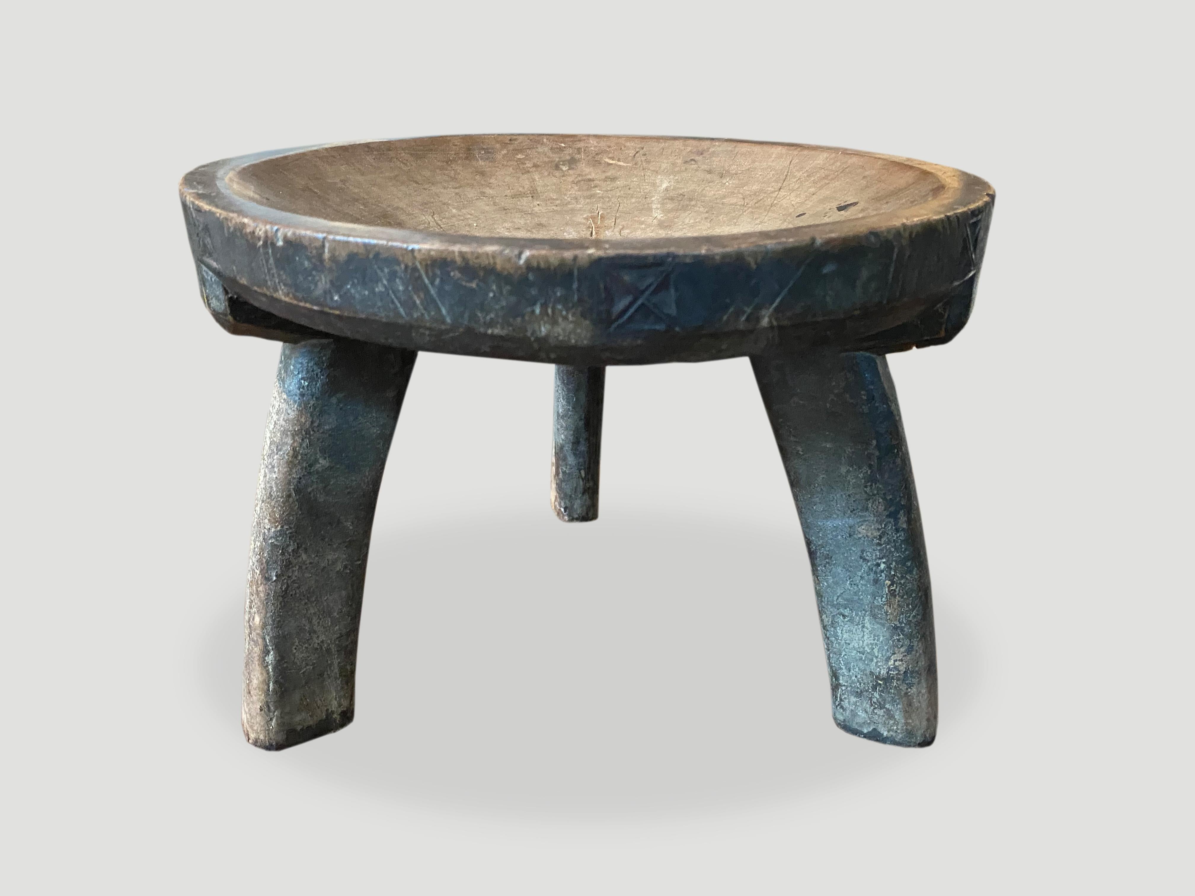 Beautiful hand carved African teak wood stool, side table or bowl with lovely patina and carvings. The entire piece is hand carved out of a single piece of wood.

This stool or bowl was sourced in the spirit of wabi-sabi, a Japanese philosophy