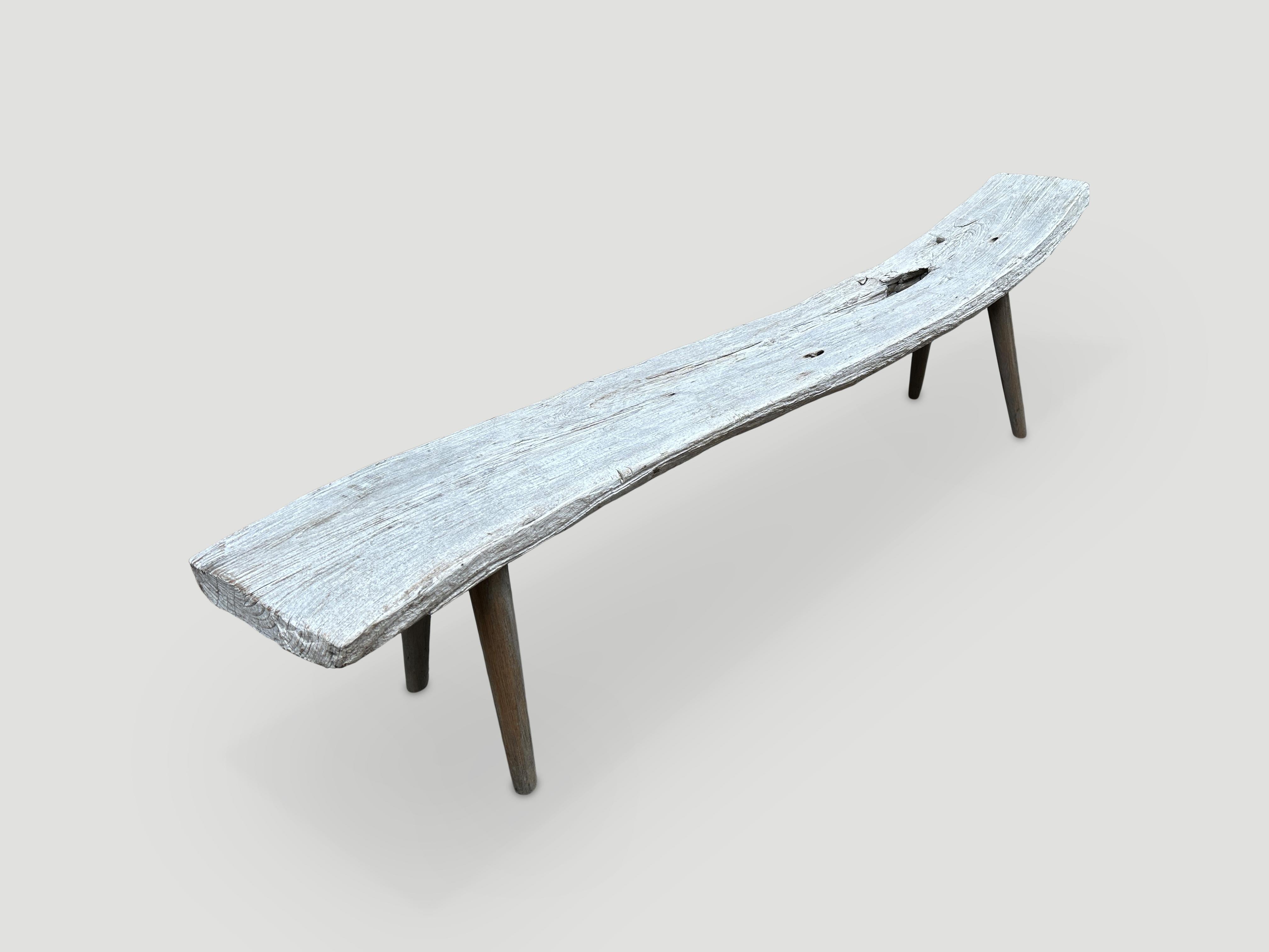 Banc en teck Wabi Sabi avec des tons de bois pâle. Nous avons ajouté des pieds minimalistes de style cône à ce magnifique panneau épais et vieilli. Le dossier s'élève à 21