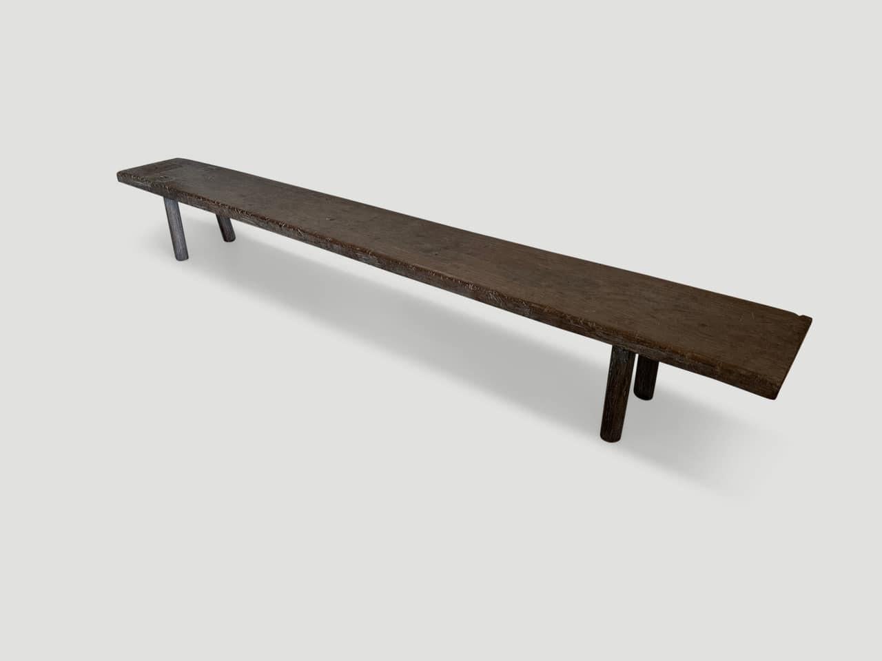 Antique bench made from a century old two inch thick panel with beautiful patina. We added smooth teak cylinder legs. Perfect for inside or outside living.

This bench was hand made in the spirit of Wabi-Sabi, a Japanese philosophy that beauty can