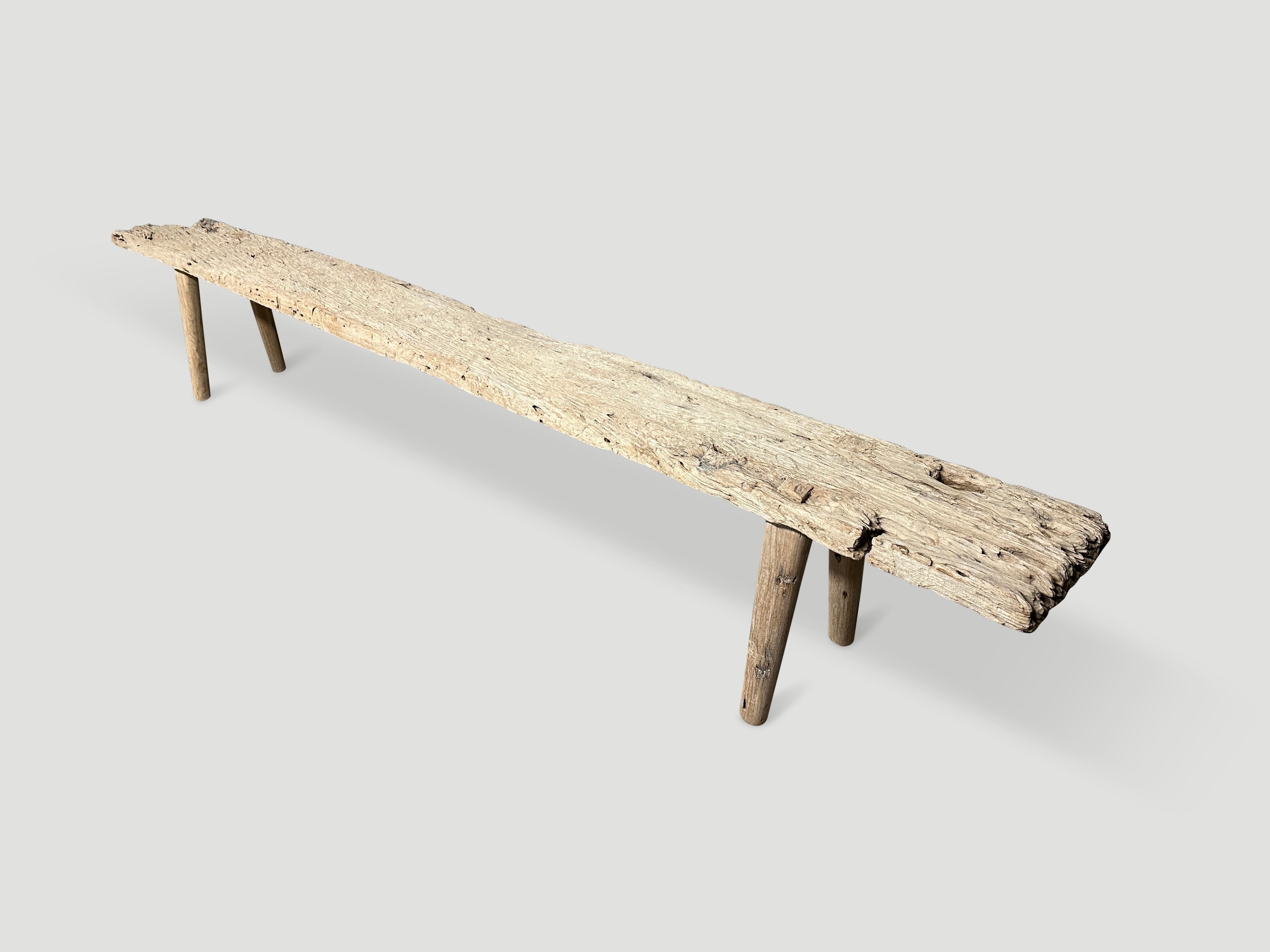 We added smooth teak minimalist legs, in contrast to this impressive ancient single wood panel with beautiful erosion detail. Circa 1900. 

This bench was handmade in the spirit of Wabi-Sabi, a Japanese philosophy that beauty can be found in
