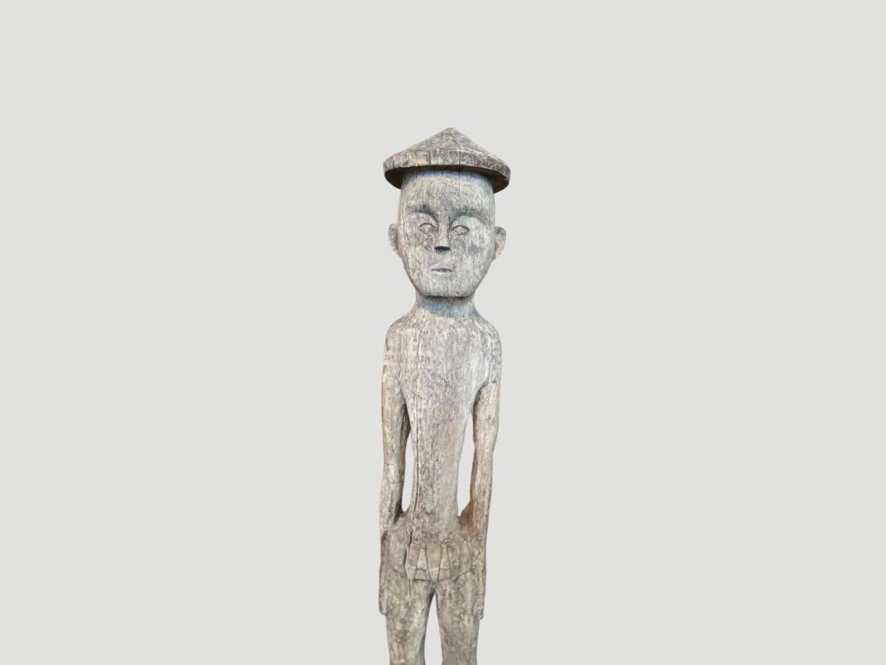 Antique male statue hand carved from a single teak wood log from West Borneo. Originally used to protect the home from evil spirits and placed into the ground in front of the house as a guardian. We have added a modern metal black base.

This