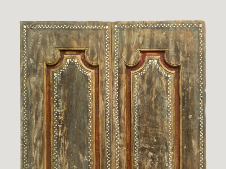 Antique temple door in teak wood with remnants of the original color. We added the shell inlay by hand. Great as a headboard, coffee table or simply as a piece of art. We currently have a large collection of temple doors available. All unique with