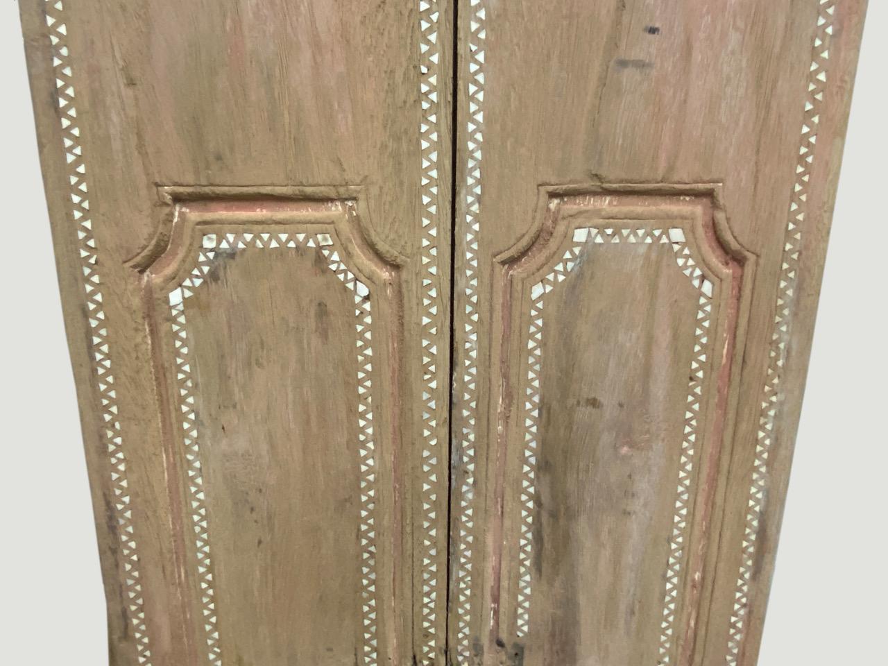 Antique temple door in teak wood with the remnants of the original pretty coral color. We added the shell inlay by hand. Great as a headboard, coffee table or simply as a piece of art. We currently have a large collection of temple doors available.