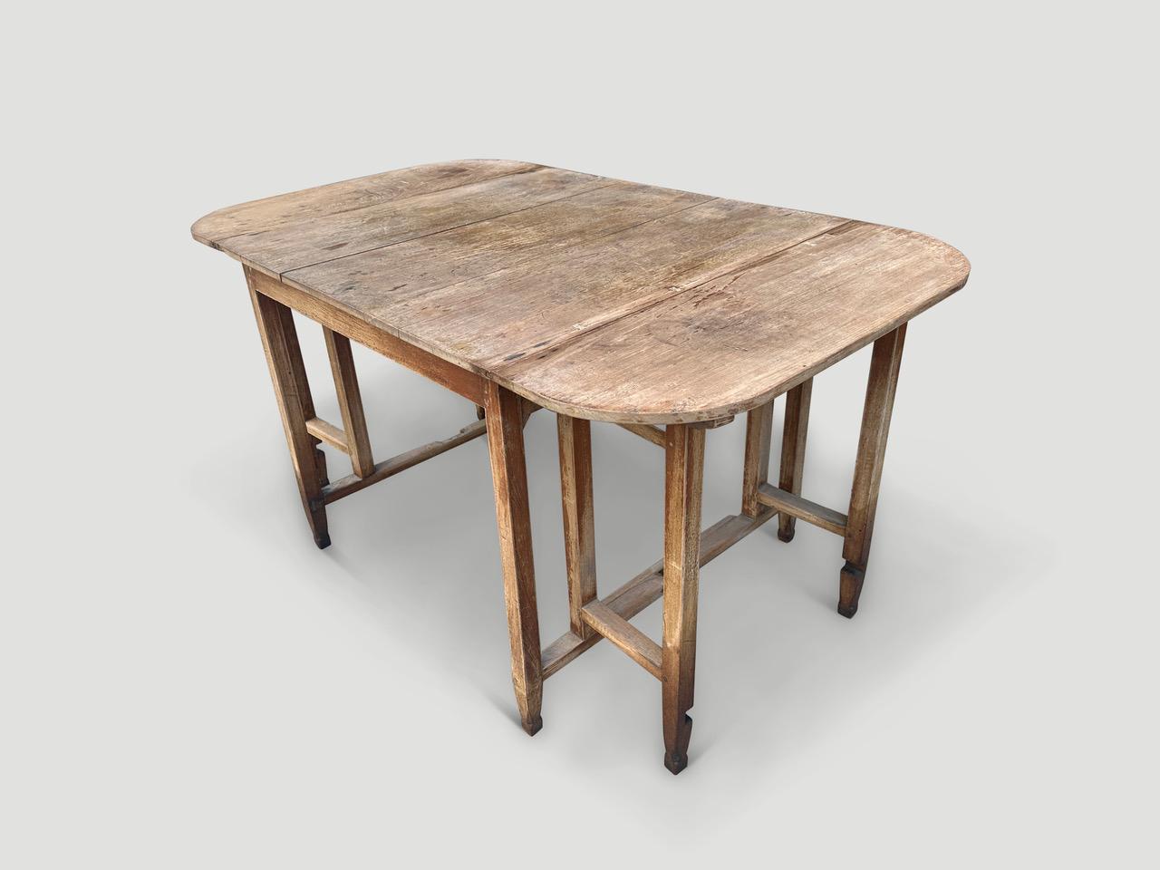Antique drop leaf dining table made from beautiful teak wood. There are small butterflies inlaid into the top of this unique hand carved dining table with original hardware. Circa 1950. Full dimensions; Closed 36 “x 36” and with the leafs open plus