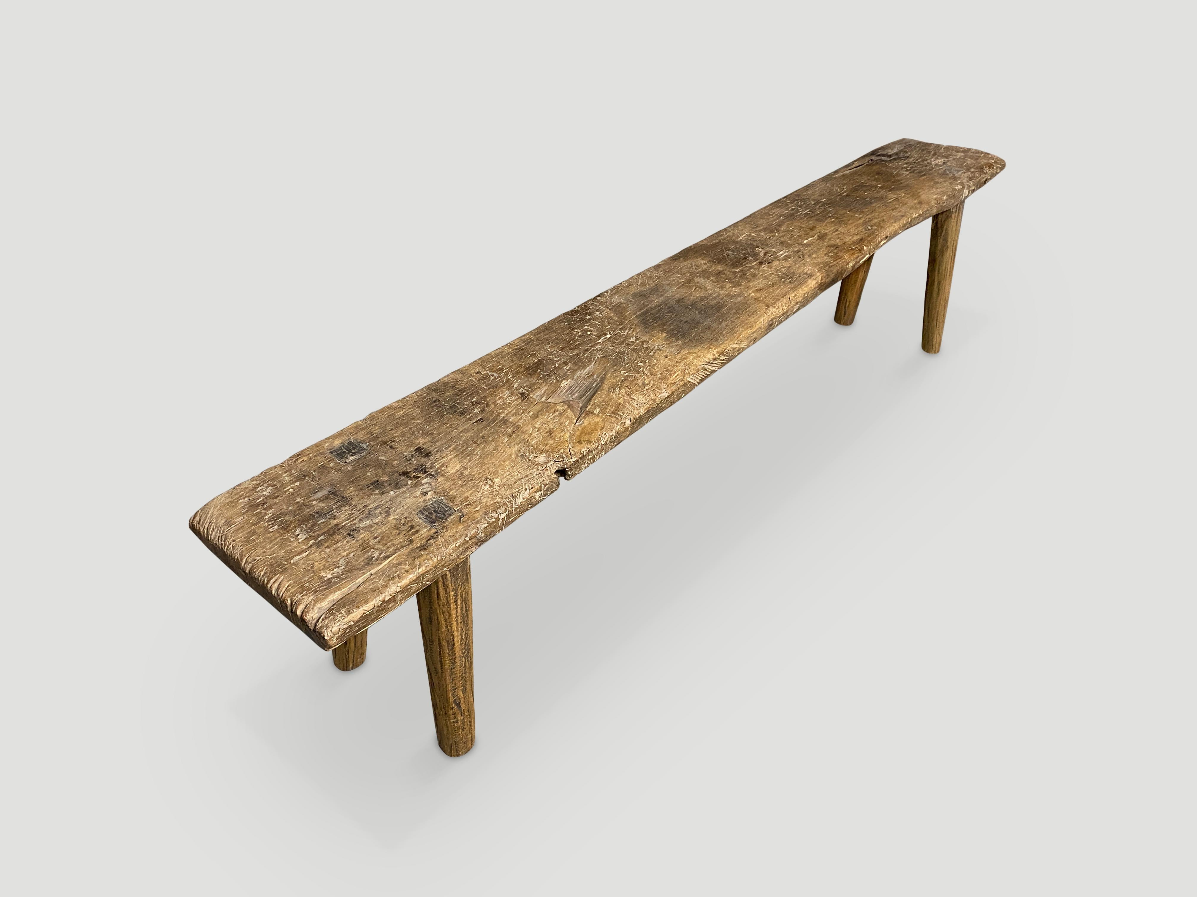 Antique hand carved Wabi Sabi bench. A single thick slab of teak celebrating the cracks and crevices and all the other marks that time and loving use have left behind. We added smooth teak minimalist legs.

This bench was hand made in the spirit