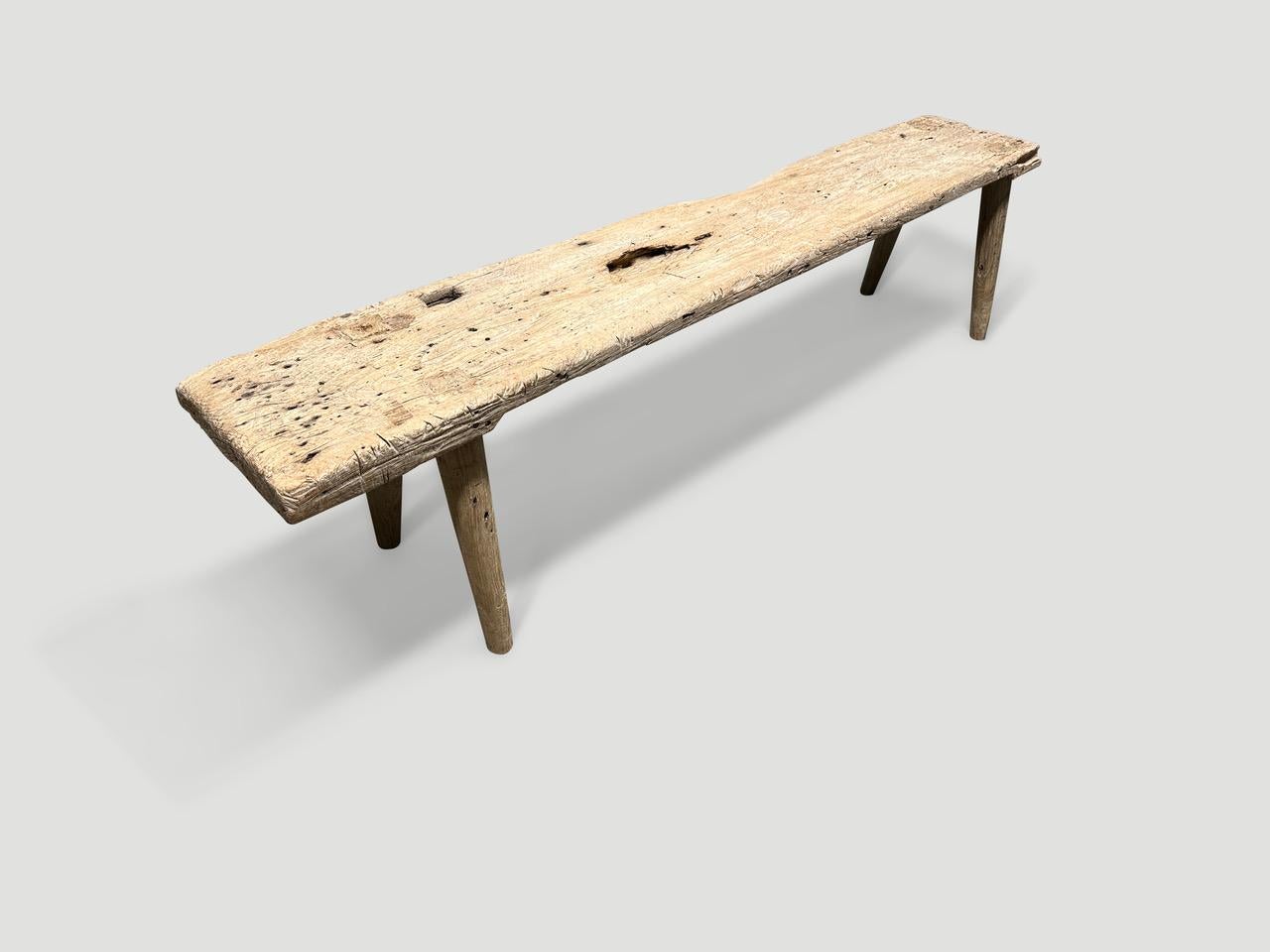 Eine einzelne dicke antike Holzplatte mit schönem Charakter. Wir haben glatte, minimalistische Teakholzbeine hinzugefügt, um diese schöne Bank herzustellen, und sie mit einer geheimen Zutat behandelt, die die einzigartige Holzmaserung zum Vorschein
