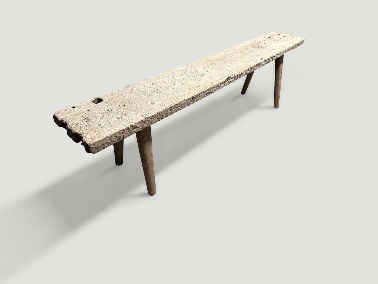 Eine einzelne dicke antike Holzplatte mit schönem Charakter im Holz. Wir haben glatte, minimalistische Teakholzbeine hinzugefügt, um diese schöne Bank herzustellen, und sie mit einer geheimen Zutat behandelt, die die einzigartige Holzmaserung zum