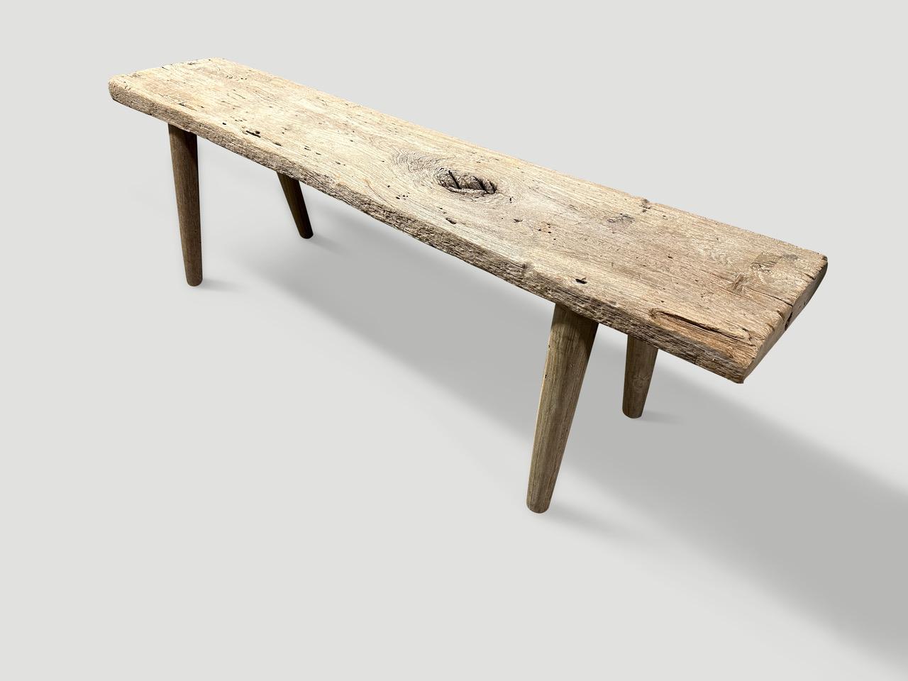 Ein einzelnes dickes antikes Paneel mit schönem Charakter im Holz. Wir haben glatte, minimalistische Teakholzbeine hinzugefügt, um diese schöne Bank herzustellen, und sie mit einer geheimen Zutat behandelt, die die einzigartige Holzmaserung zum