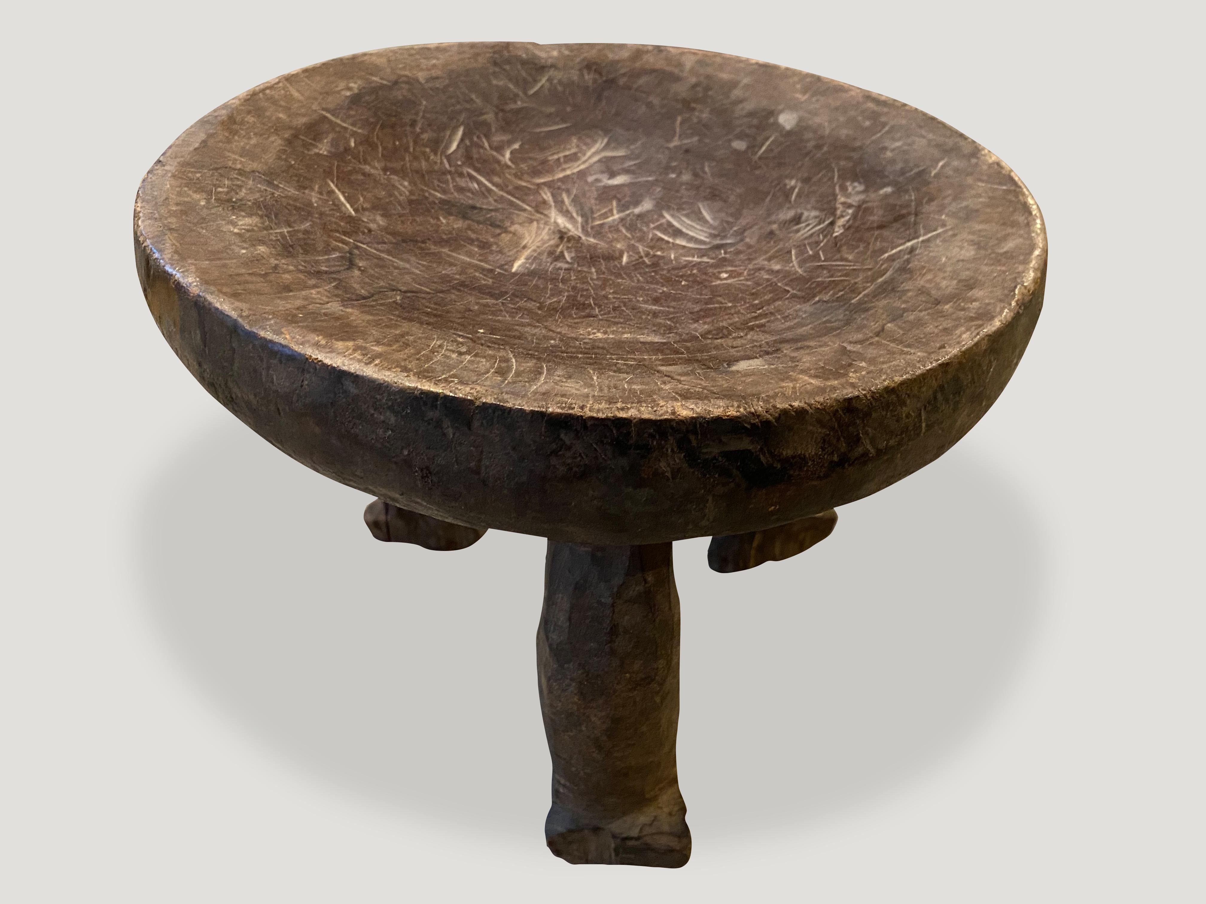 Beautiful hand carved African side table or stool with lovely patina. Celebrating the cracks and crevices and all the other marks that time and loving use have left behind. The entire piece is hand carved out of a single block of mahogany
