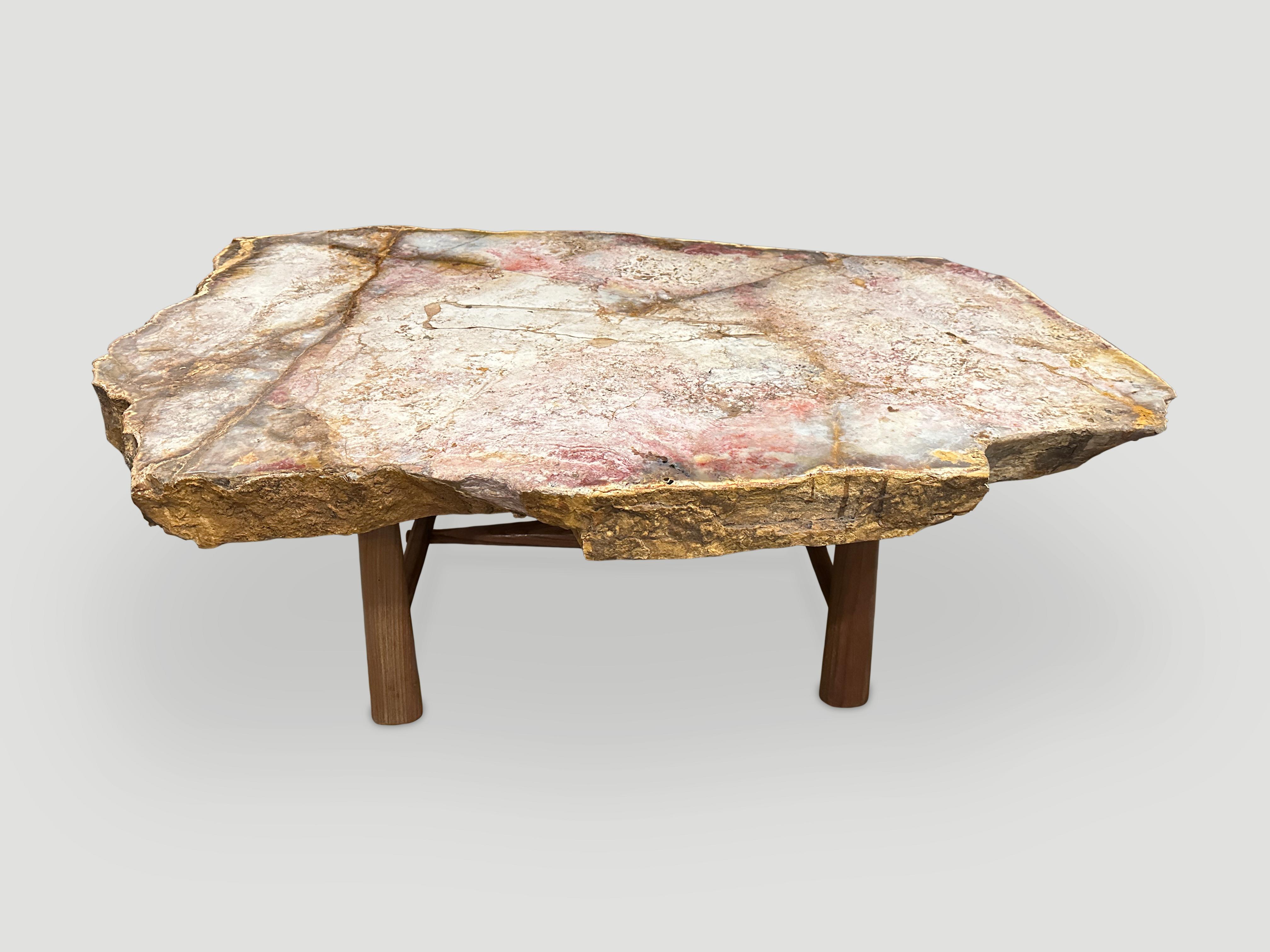 Impressive three inch slab top with the most beautiful color tones. This petrified wood is called ‘Pancawarna’ and hard to source in such a large slab. Resting on a natural teak mid century style base. It’s fascinating how Mother Nature produces