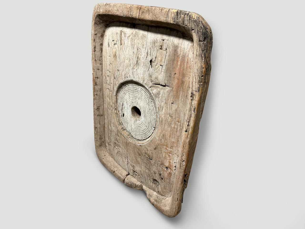 The top of an original antique rice pounder taken from my private collection. We added hand cut mother of pearl shell into the center of this beautiful rare teak wood. Great as an art installation. All one of a kind. Please inquire.

This art piece