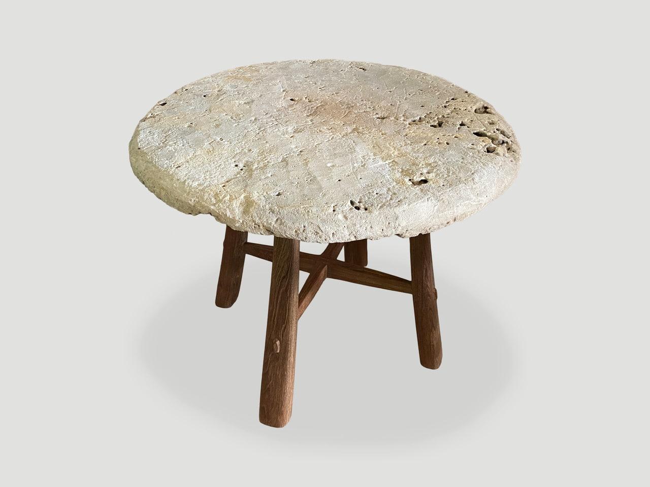 Impressionnante pierre antique de deux pouces d'épaisseur provenant de l'île de Sumba. Nous avons ajouté des pieds en bois de teck de style mid-century en contraste. Parfait comme table d'appoint, table d'entrée ou petite table à manger.