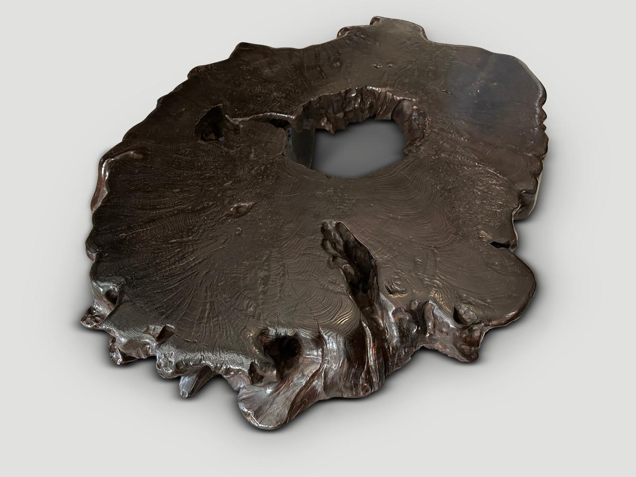 Impressionnante table basse en bois de teck centenaire. Nous avons ajouté quatre pieds coniques et fini le plateau avec une teinture expresso révélant le magnifique grain du bois. Fait partie de la Collectional Mid Century Couture. Meubles