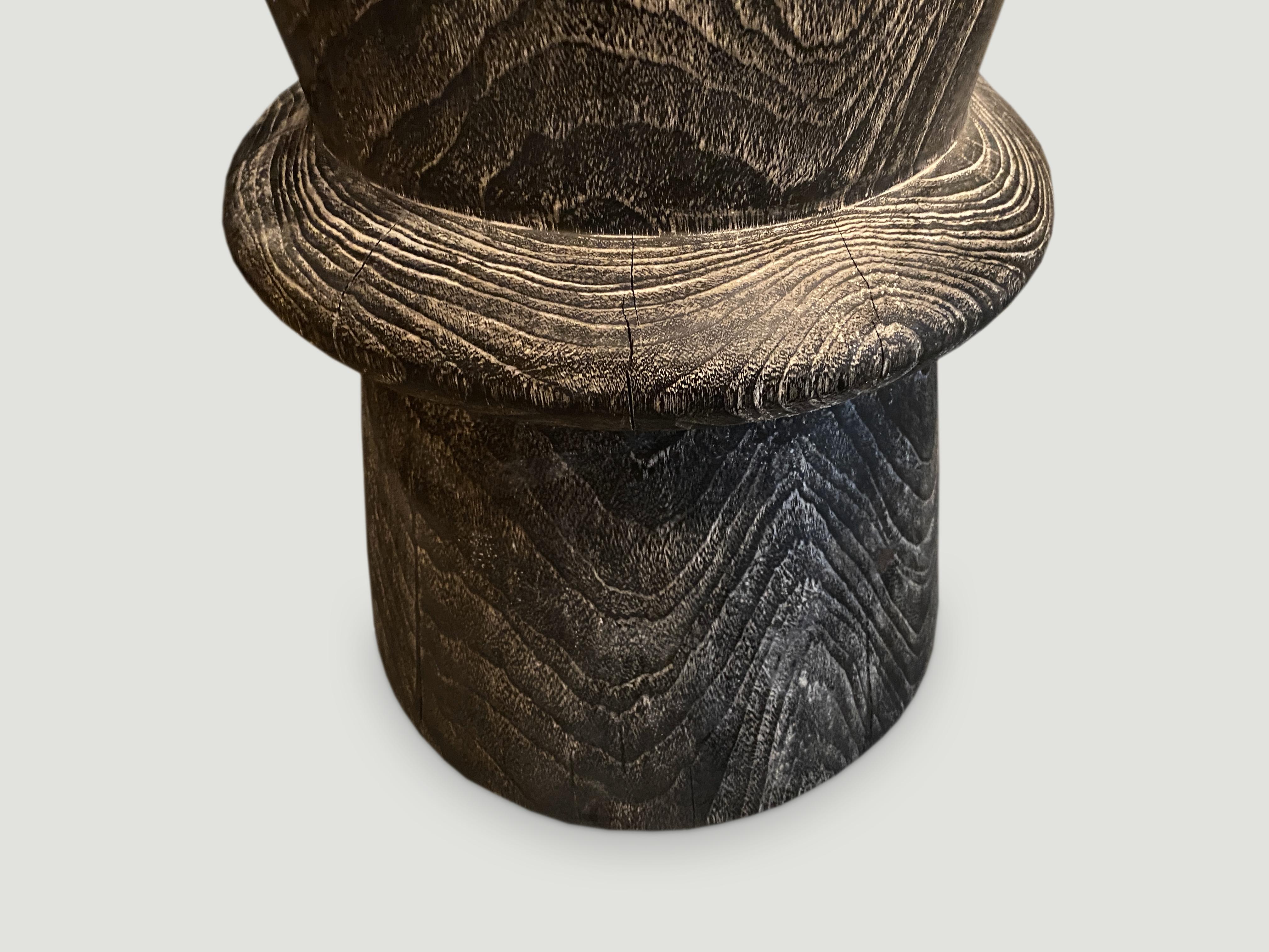 Hand carved side table made from reclaimed teak wood that we have charred one time and added a cerused finish. We have a collection. The price and size reflects the one shown.

Andrianna Shamaris.
