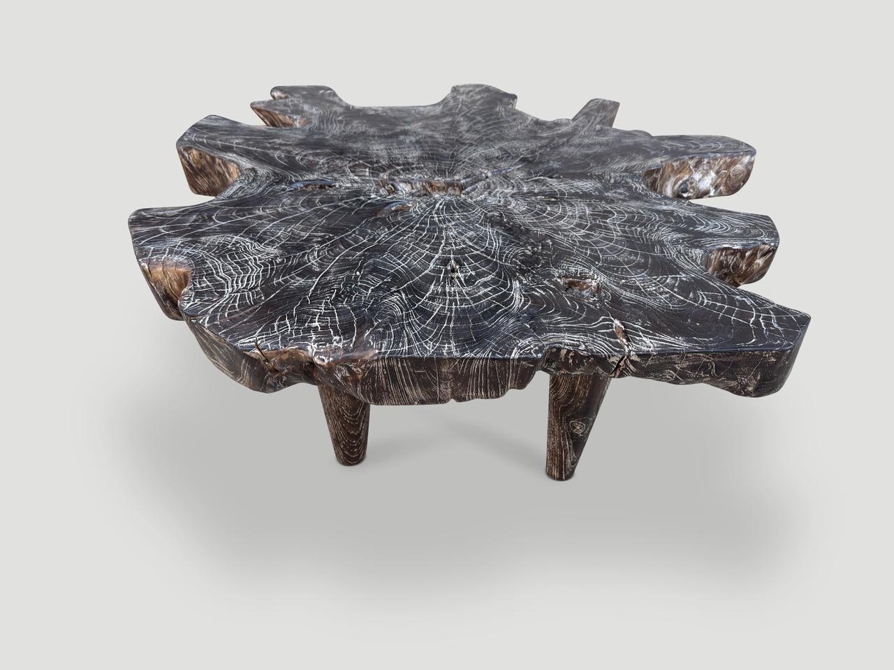 Une impressionnante plaque de teck récupéré de trois pouces d'épaisseur a été carbonisée une fois pour produire cette table basse unique. Nous avons ajouté quatre pieds en forme de cône de style milieu de siècle et une finition cérusée révélant le