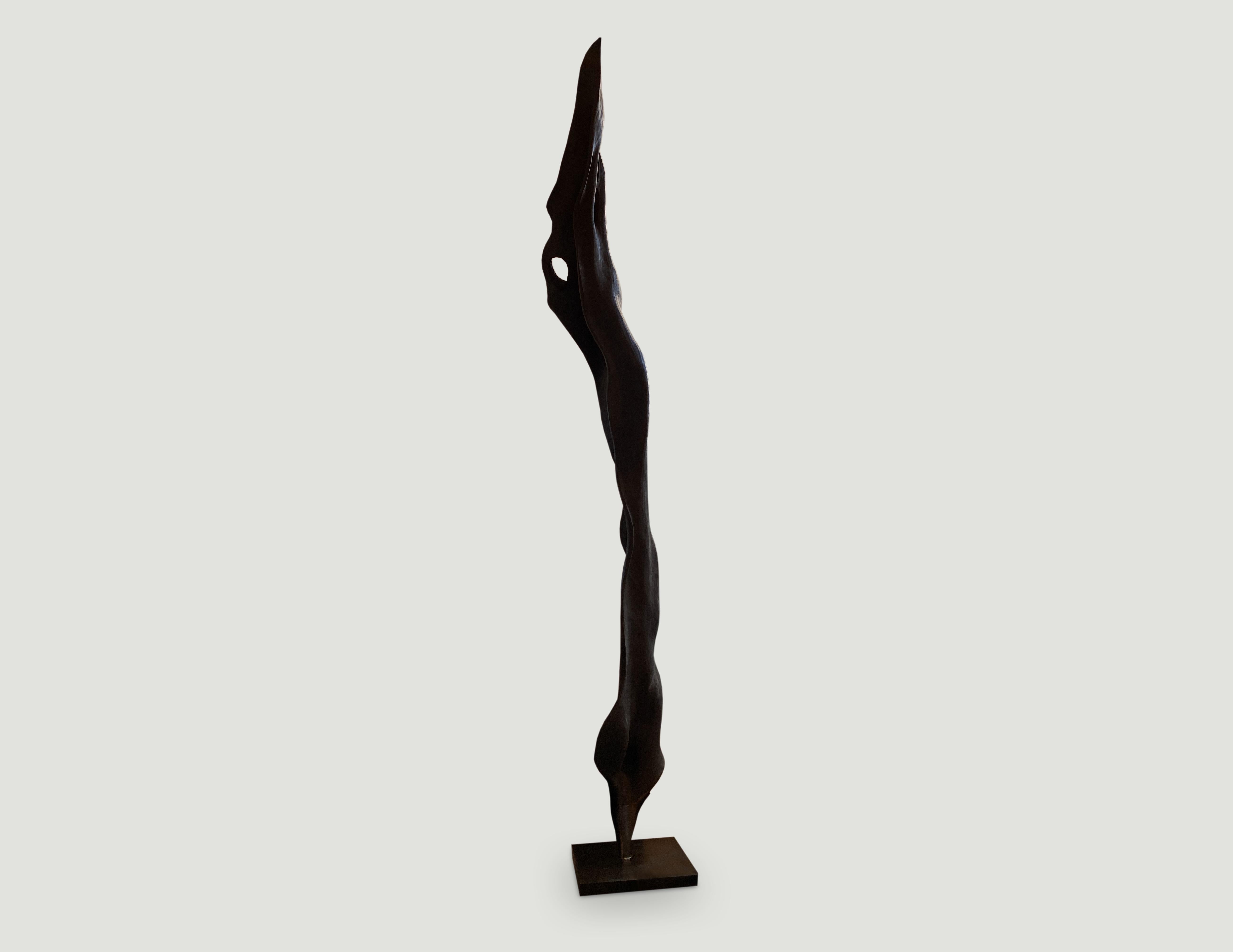 Impressive hand carved sculpture made from a single piece of mango wood and set on a modern black 18