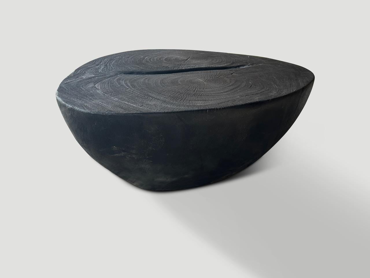 Magnifique table basse minimaliste en bois de suar récupéré. Carbonisé à trois reprises, il révèle le grain unique du bois. Sculpté à la main avec une graduation spectaculaire de la base au sommet. À la fois sculptural et utilisable. Tout est dans