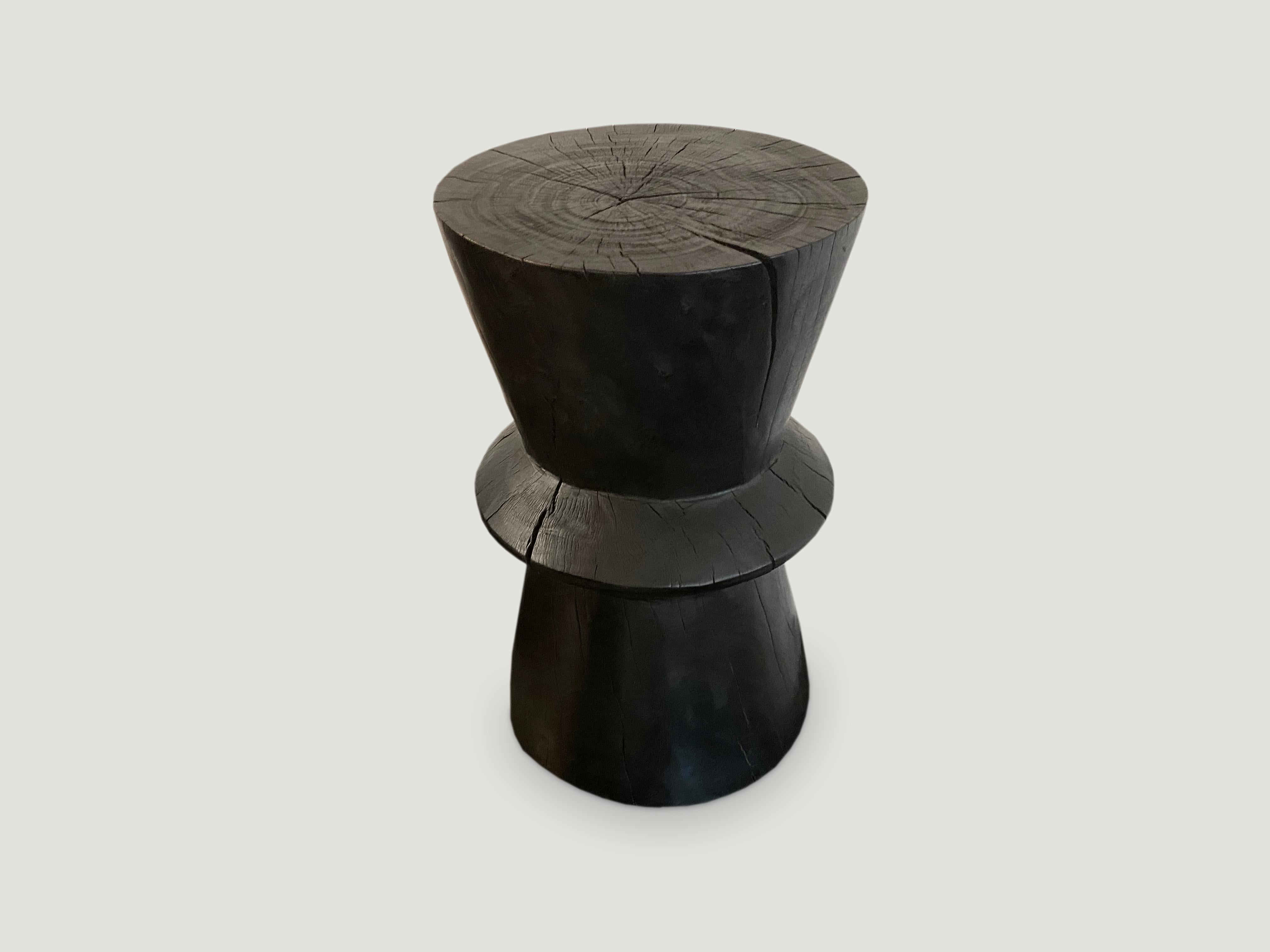Hand carved side table made from reclaimed tamarind wood that celebrates cracks and crevices.

The Triple Burnt collection represents a unique line of modern furniture made from solid reclaimed wood. Burnt three times to produce a rich, charcoal