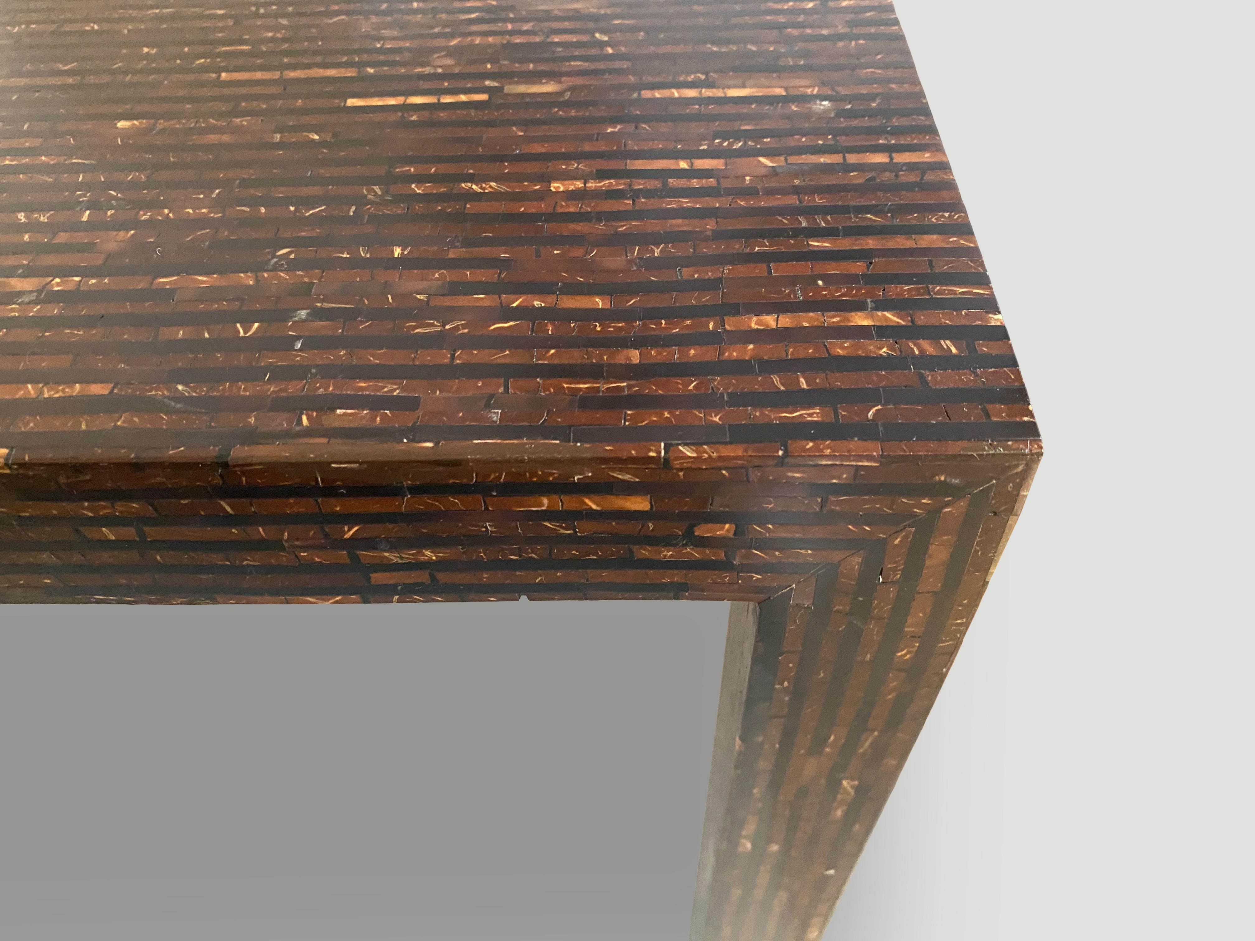 Beautiful hand made one of a kind table. Tiny pieces of coconut shell are meticulously joined together by hand to form this impressive minimalist table. Multiple applications such as console, dining table, entrance table or desk. The legs and the