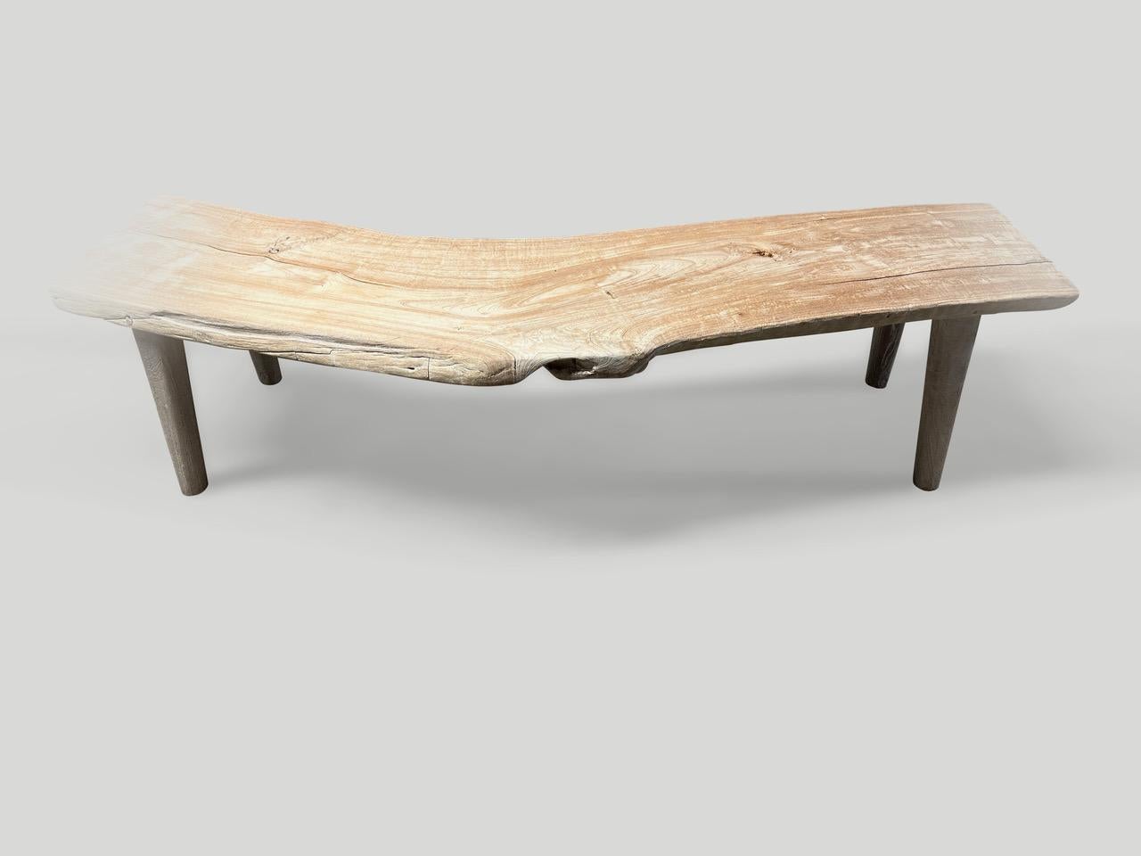 Un unico pannello in legno antico di grande spessore con un carattere unico e una curva naturale del legno. Per contrasto abbiamo aggiunto delle gambe minimaliste in teak liscio. Sbiancato con un leggero lavaggio bianco che rivela le bellissime
