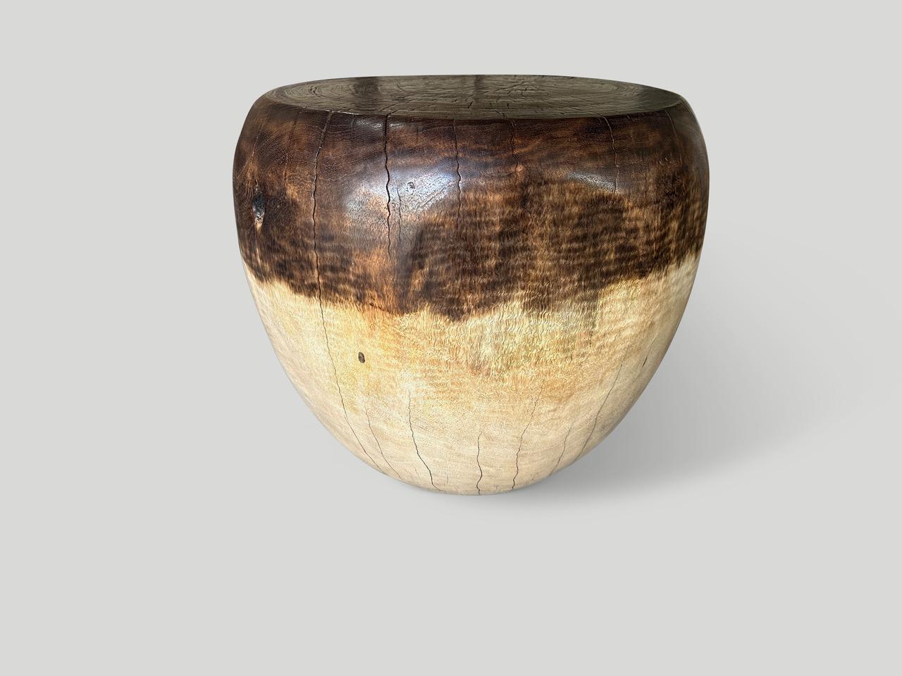 Table d'appoint en bois de manguier récupéré, sculptée à la main en forme de tambour. Nous avons partiellement teinté la moitié supérieure en brun chocolat et ajouté une huile naturelle révélant les magnifiques veines du bois. Tout est dans les