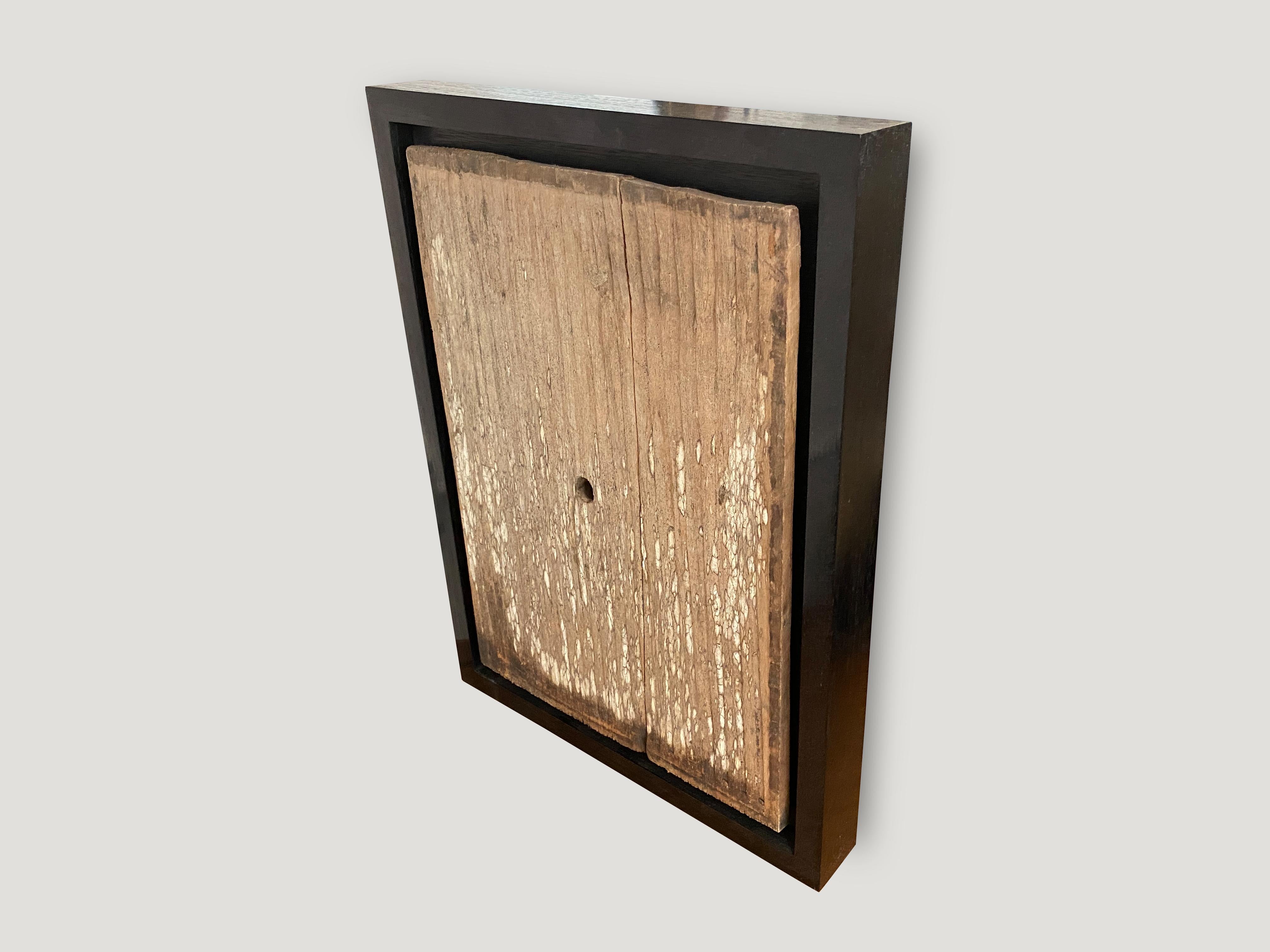 Antique hand carved panel from Toraja. Framed in a Minimalist black teak wood shadow box. This carving symbolizes the protection of the home. Great art piece.

This antique carving was sourced in the spirit of wabi-sabi, a Japanese philosophy that