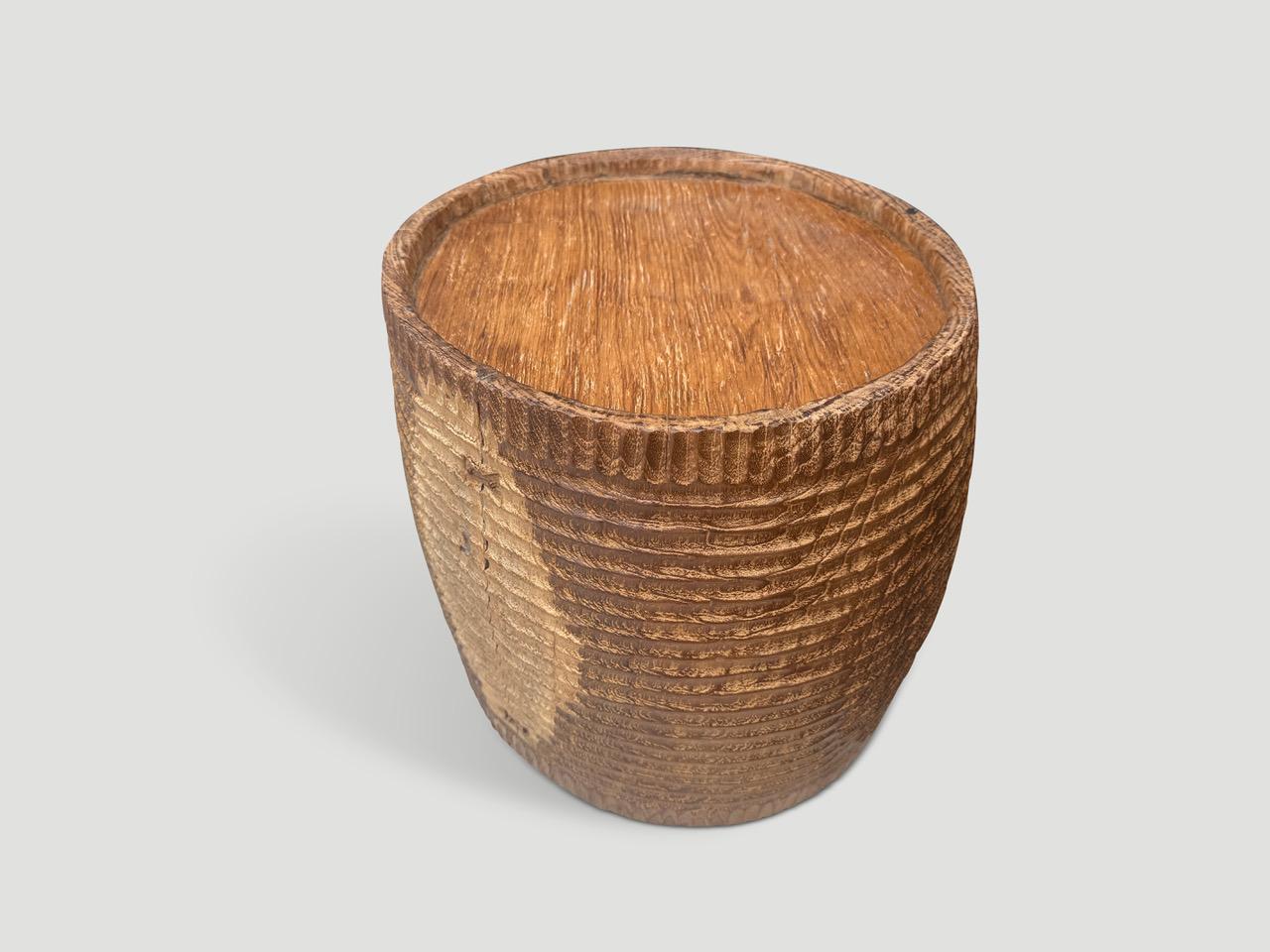 Originally used to carry water, this antique container has been hand carved by our master carver to produce a sculptural container or if turned the opposite direction, a unique side table. We added butterfly details on the side and finished with a