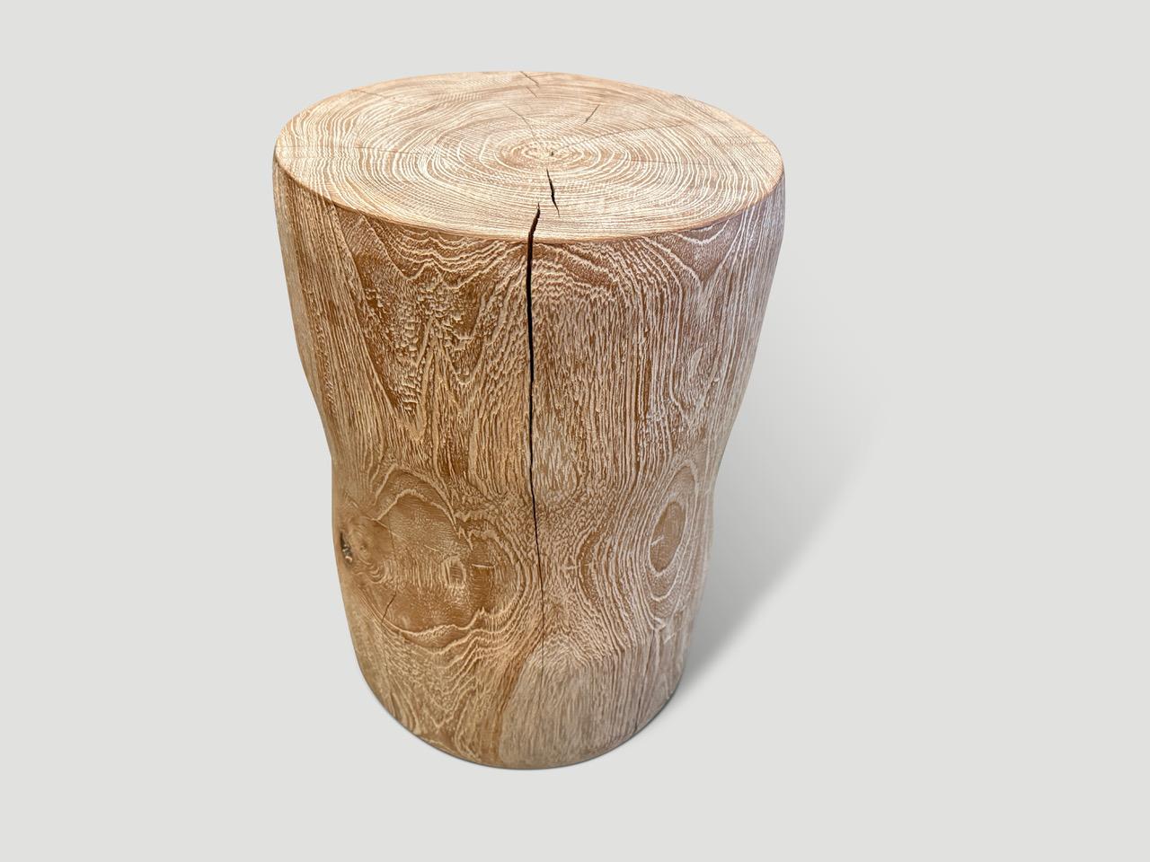 Hand carved cerused teak side table or stool with a subtle hourglass shape. Celebrating the cracks and crevices found in reclaimed teak wood. This style works well in a variety of settings such as seating or side tables, as shown in the bottom image
