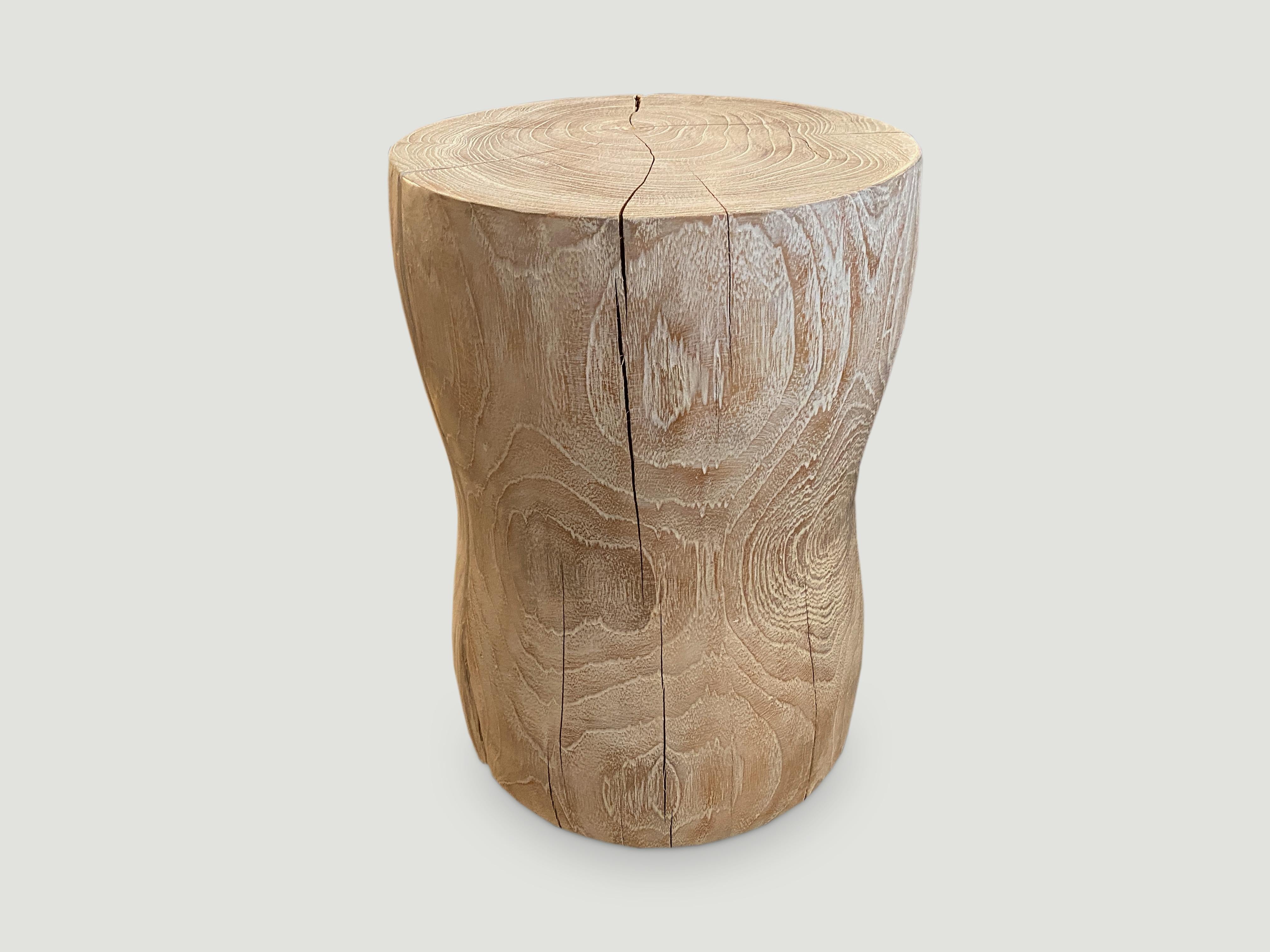 Hand carved teak side table or stool with a subtle smooth hourglass shape that celebrates the cracks and crevices found in reclaimed teak. This style works well in a variety of interior settings such as seating or side tables, as shown in the bottom