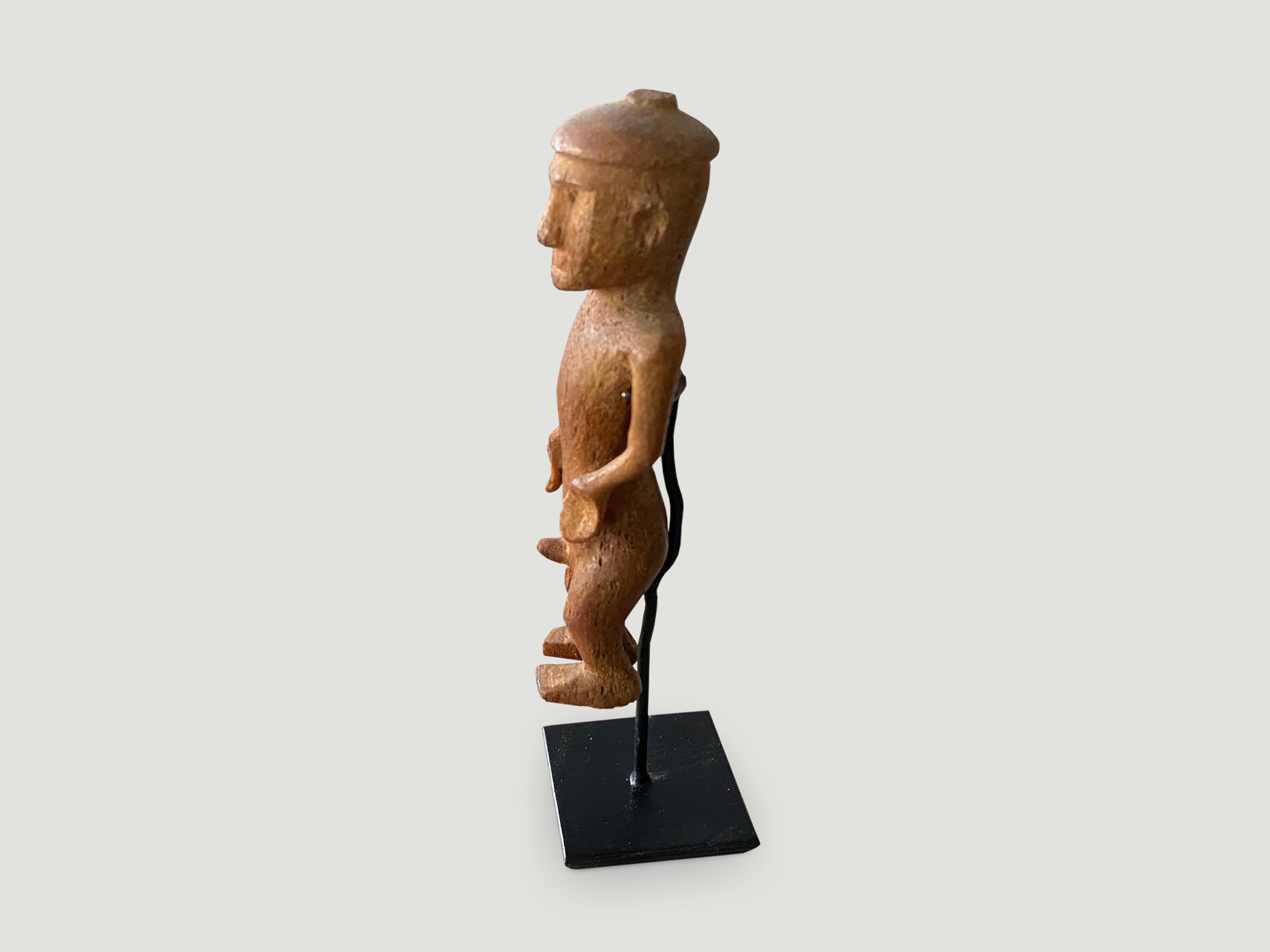 Hand carved wooden figurine of a Primitive man from Sumatra. Set on a modern black metal stand, circa 1950

This figurine was sourced in the spirit of wabi-sabi, a Japanese philosophy that beauty can be found in imperfection and impermanence. It