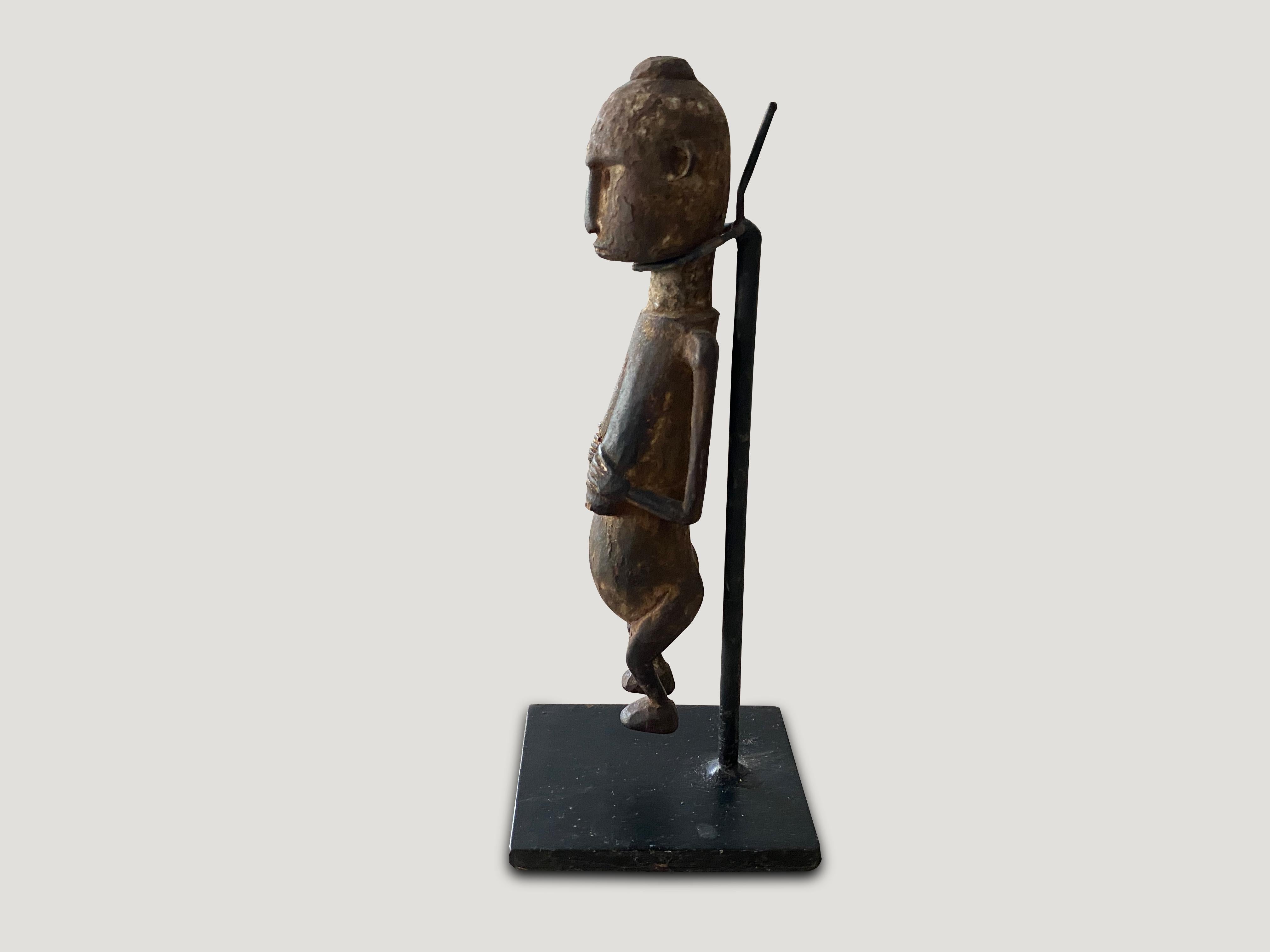 Hand carved wooden figurine of a Primitive man from Sumatra. Set on a modern black metal stand, circa 1950

This figurine was sourced in the spirit of wabi-sabi, a Japanese philosophy that beauty can be found in imperfection and impermanence. It