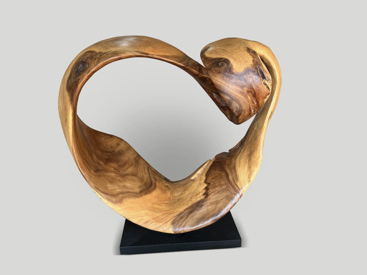 Beautiful heart shaped sculpture made from a seamless piece of suar wood and set on a minimalist black metal base. Finished with a natural oil revealing the unique wood grain. Full dimensions; 32